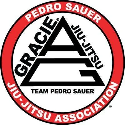 Logo of Team Pedro Sauer Jiu-Jitsu Association featuring a red and black circular emblem with a triangle and the words 'Grappling,' 'Jiu-Jitsu,' and 'Team Pedro Sauer'.