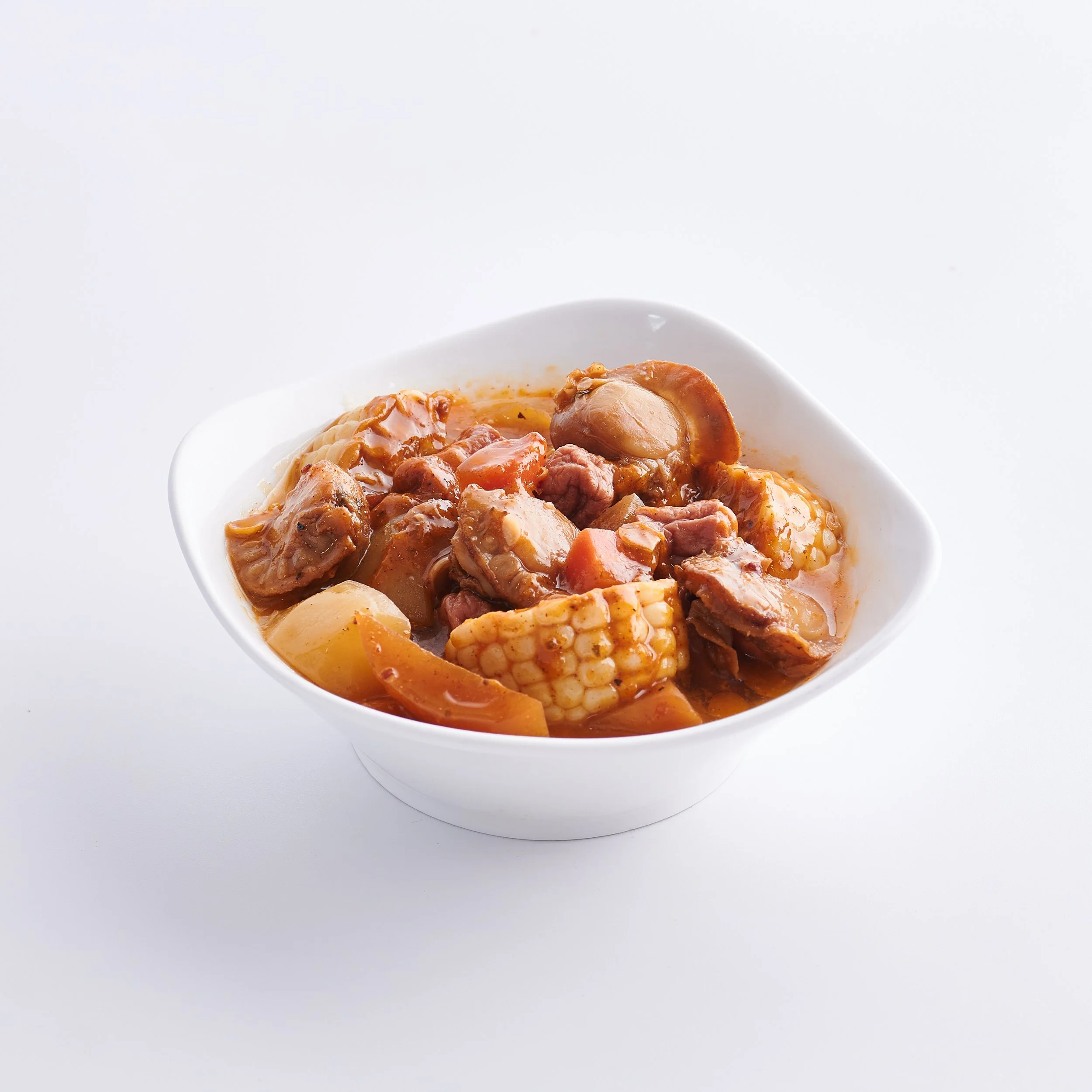 A white bowl filled with beef and vegetable stew, including chunks of beef, potatoes, carrots, and corn in a thick sauce.