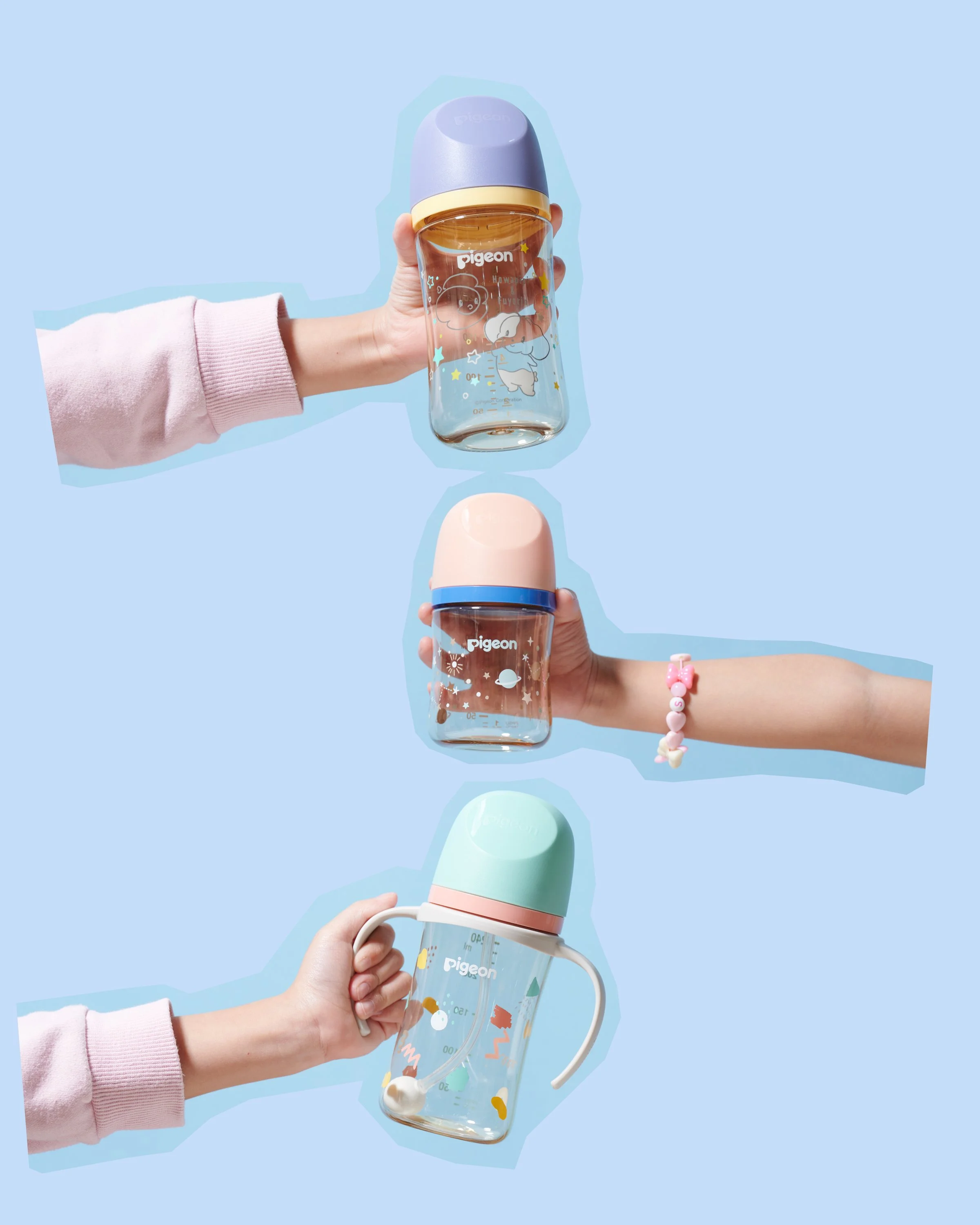 Three different colorful baby bottles with pastel caps held by hands against a light blue background.