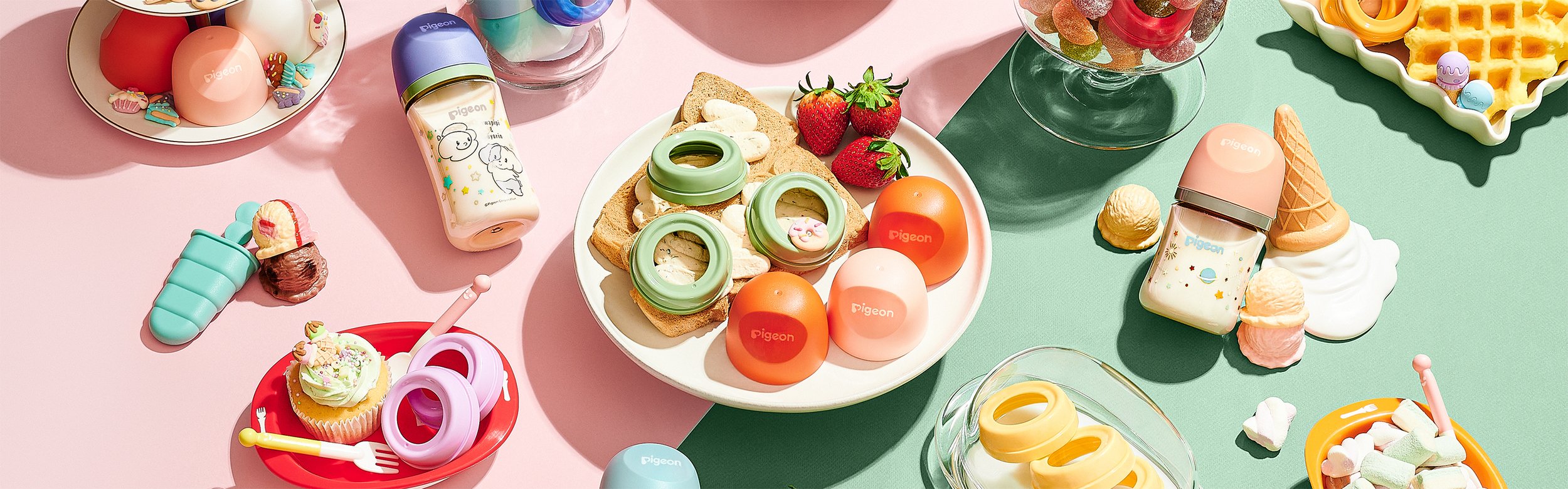 Colorful assortment of toy food and drinks, including eggs, sandwiches, strawberries, ice cream cones, waffle, and candies, arranged on pastel-colored surfaces.