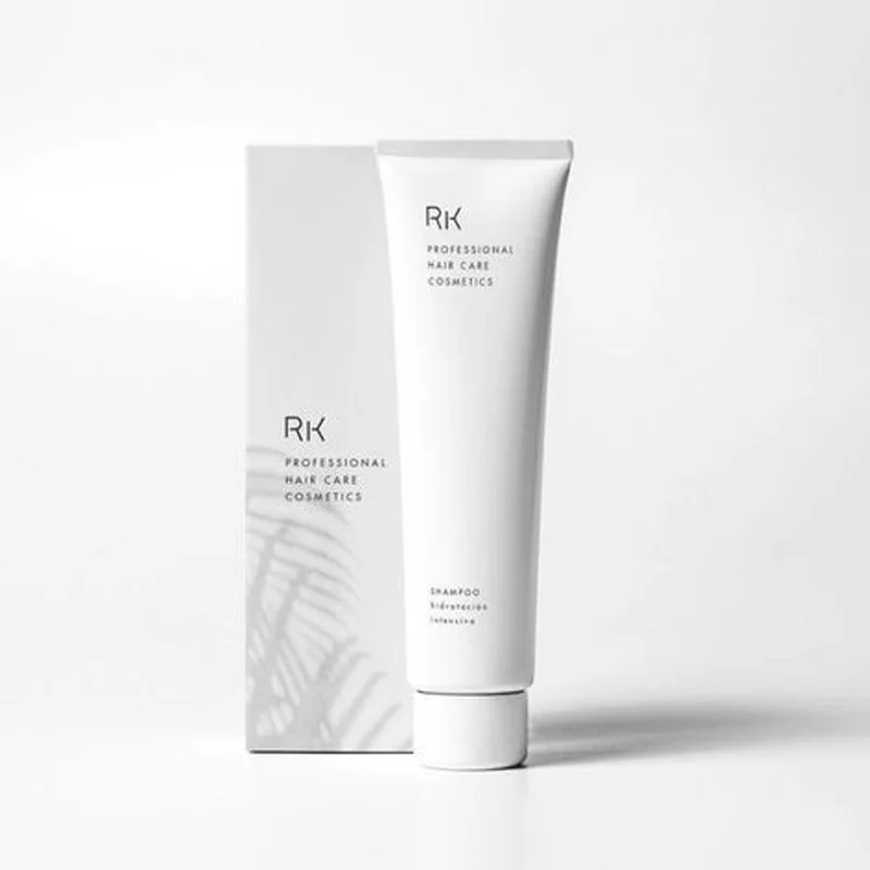 White tube of RK professional hair care shampoo standing next to its matching box on a white background.