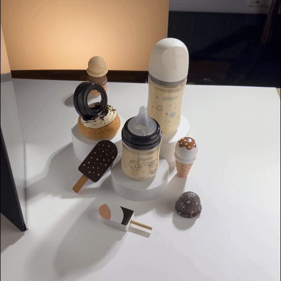 Display of various ice cream-themed objects, including ice cream cone figurines, a popsicle, a milk shaker, and a cookie-shaped item on a white table.