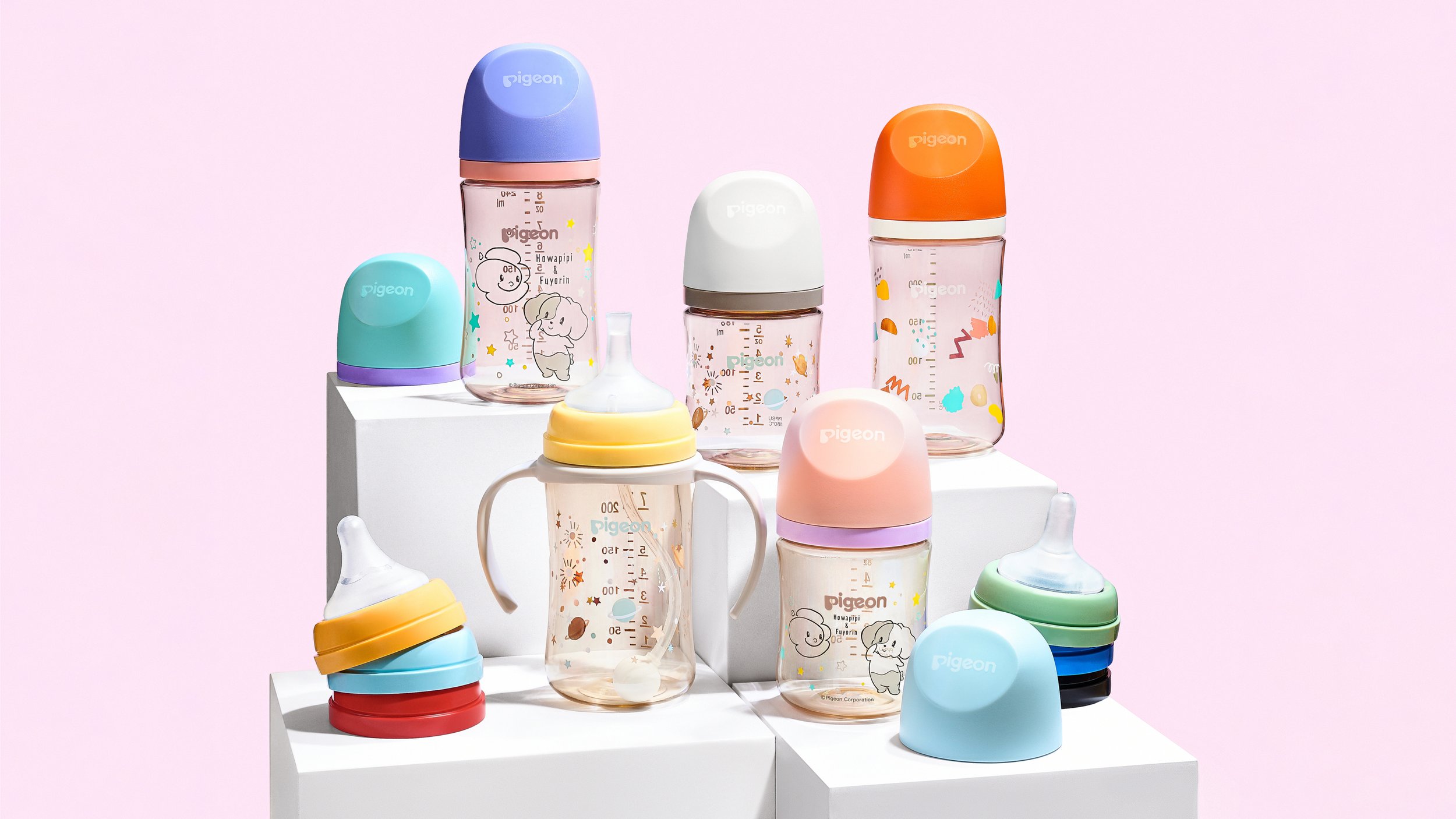 Various baby bottles and caps in pastel colors arranged on white platforms against a pink background.