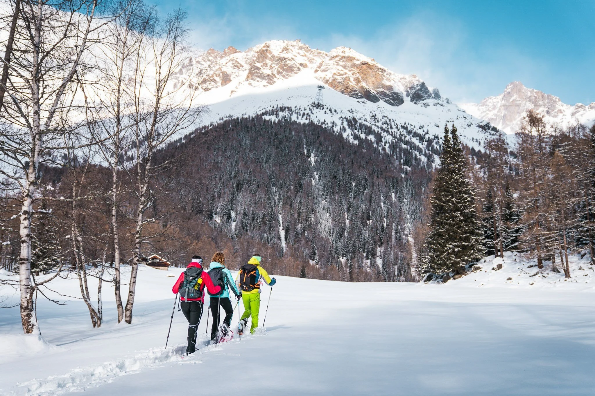 A paddleboarder glides across still waters with a mountain scene behind her