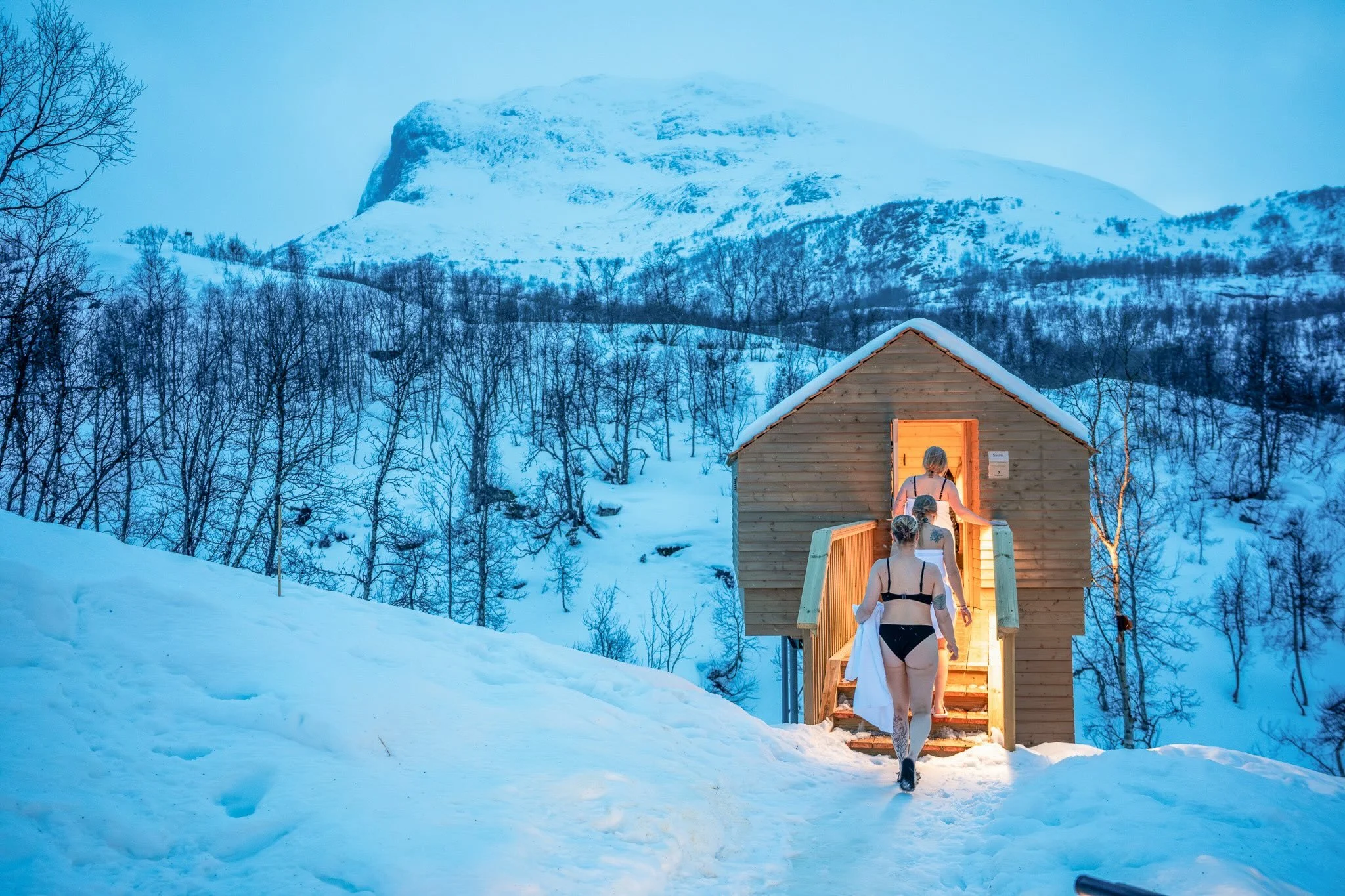 A paddleboarder glides across still waters with a mountain scene behind her