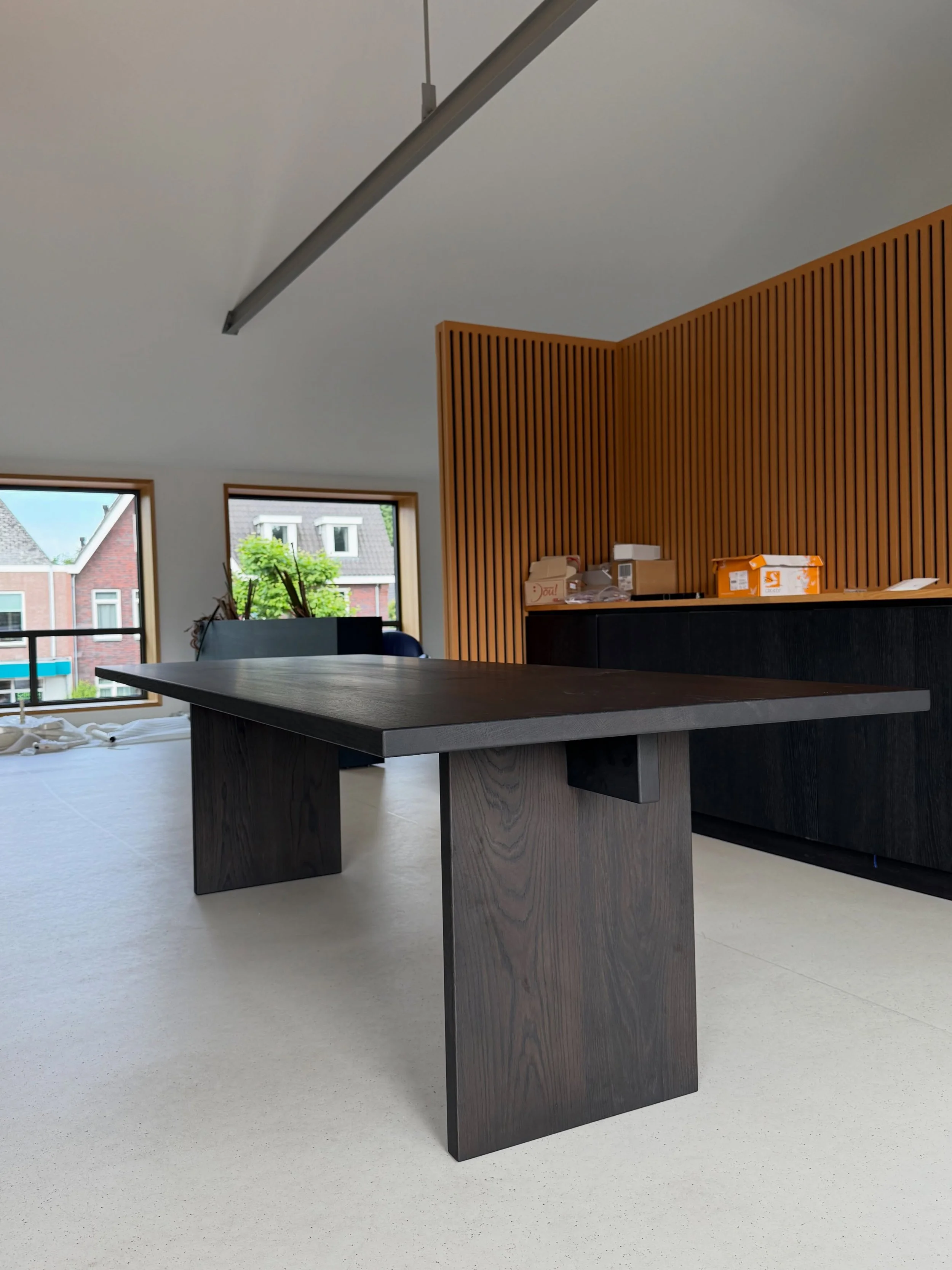 Hetzelfde ontwerp, een totaal andere uitstraling.
Op de eerste foto&rsquo;s geeft de houten poot de tafel een warme en rustige uitstraling, terwijl op de laatste foto&rsquo;s de stalen poot met metallic lak en de 45&deg; facetrand zorgt voor een stra