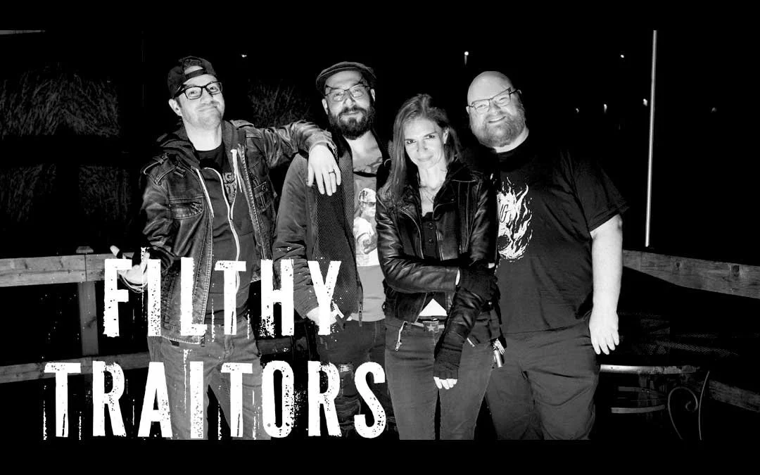 Four band members standing together outdoors at night, with the text 'Filthy Traitors' overlaid at the bottom.