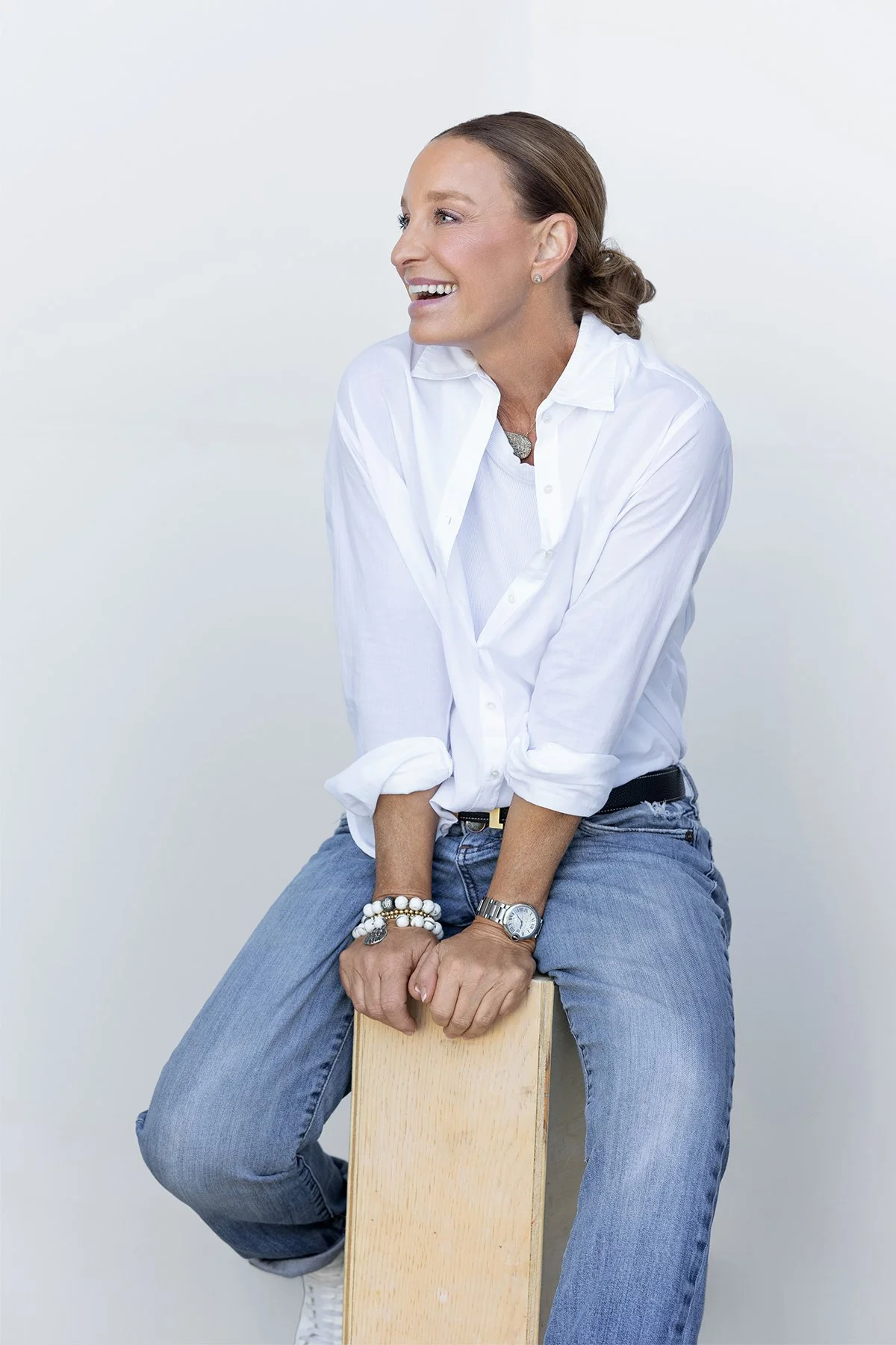 Studio portrait of Gena Wueste sitting on an apple box during her 40 Over 40 portrait session photographed by Newport Beach portrait photographer Alex Abercrombie