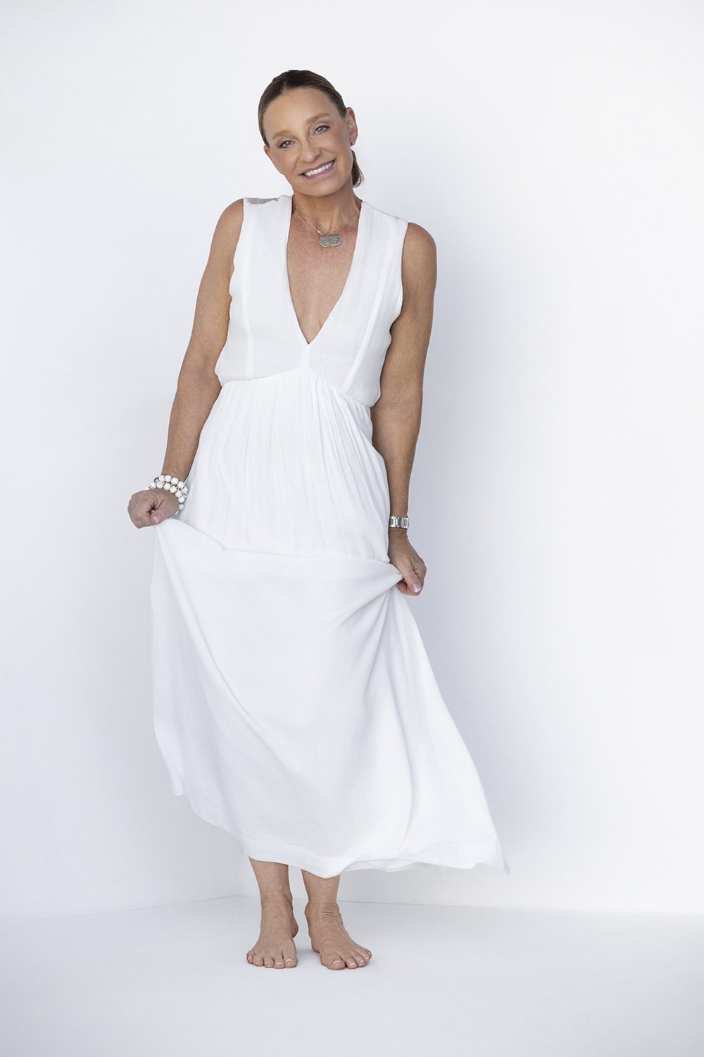 Studio portrait of Gena Wueste in a white dress on a white background during her 40 Over 40 portrait session photographed by Newport Beach portrait photographer Alex Abercrombie