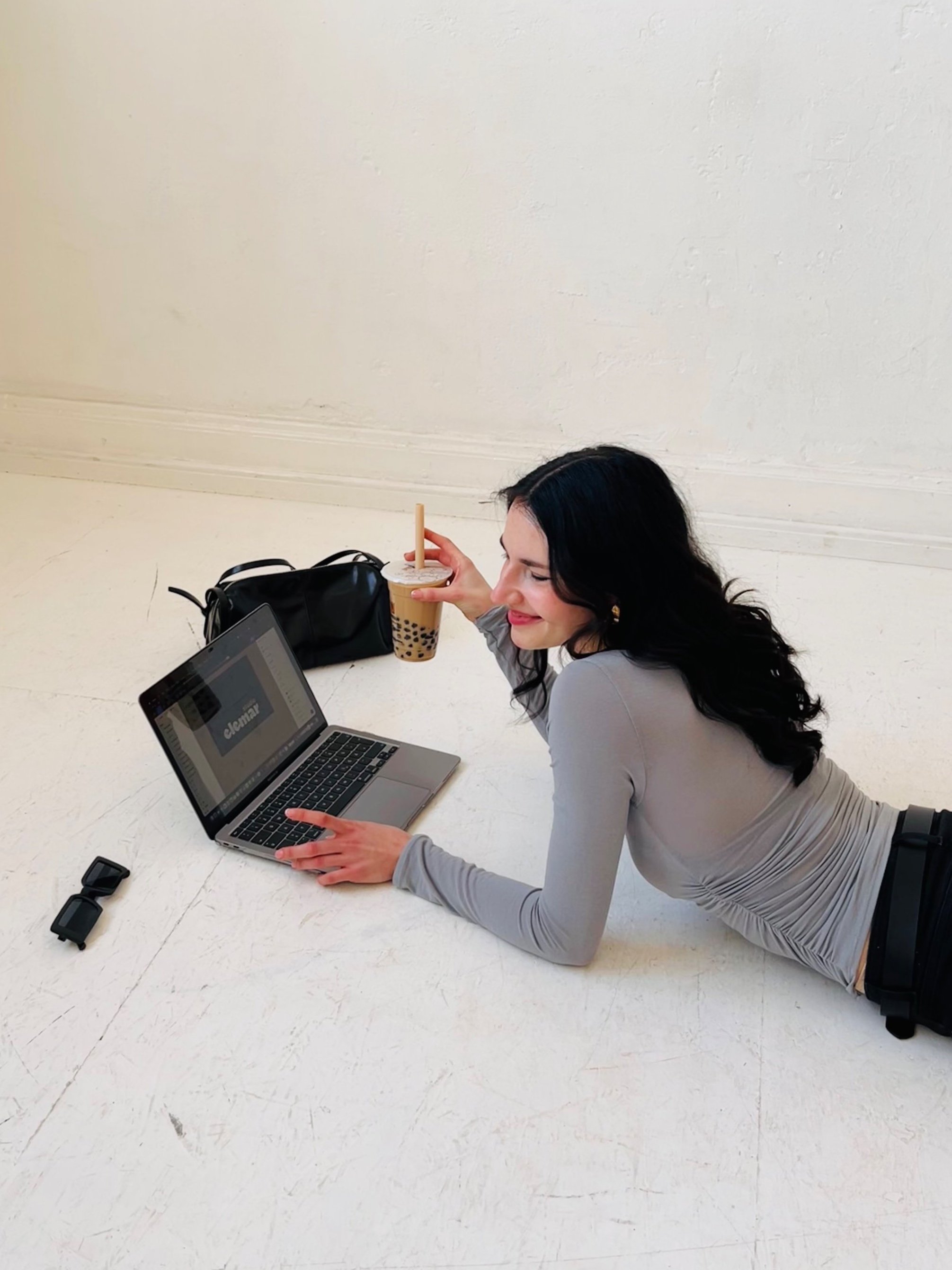 Virtual Assistant Marina sitting at a laptop and sipping on a boba