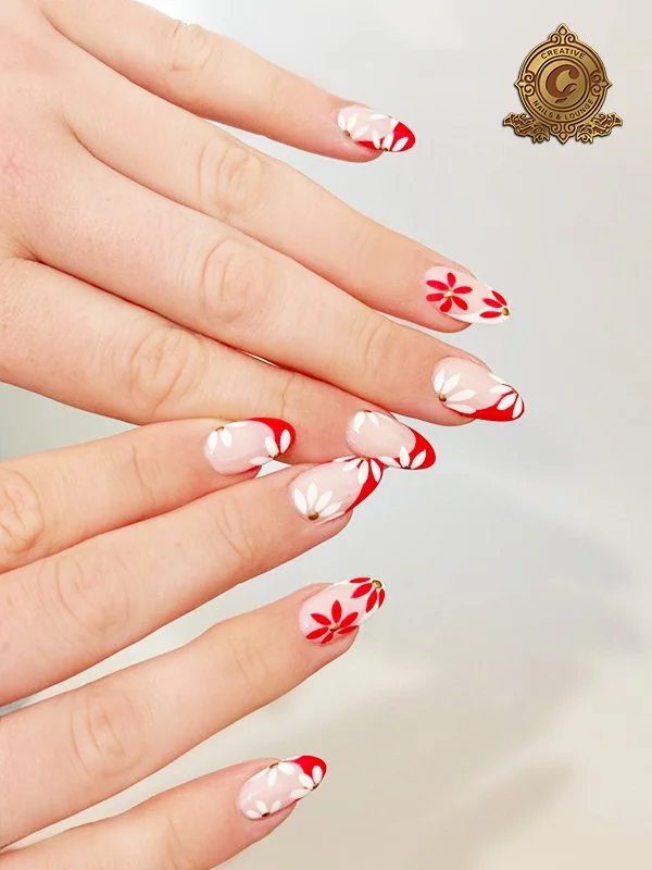 Manicured hands with red and white floral nail art