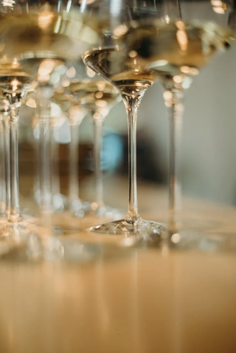 Multiple empty champagne glasses arranged on a table with some glasses in focus and others blurred in the background.