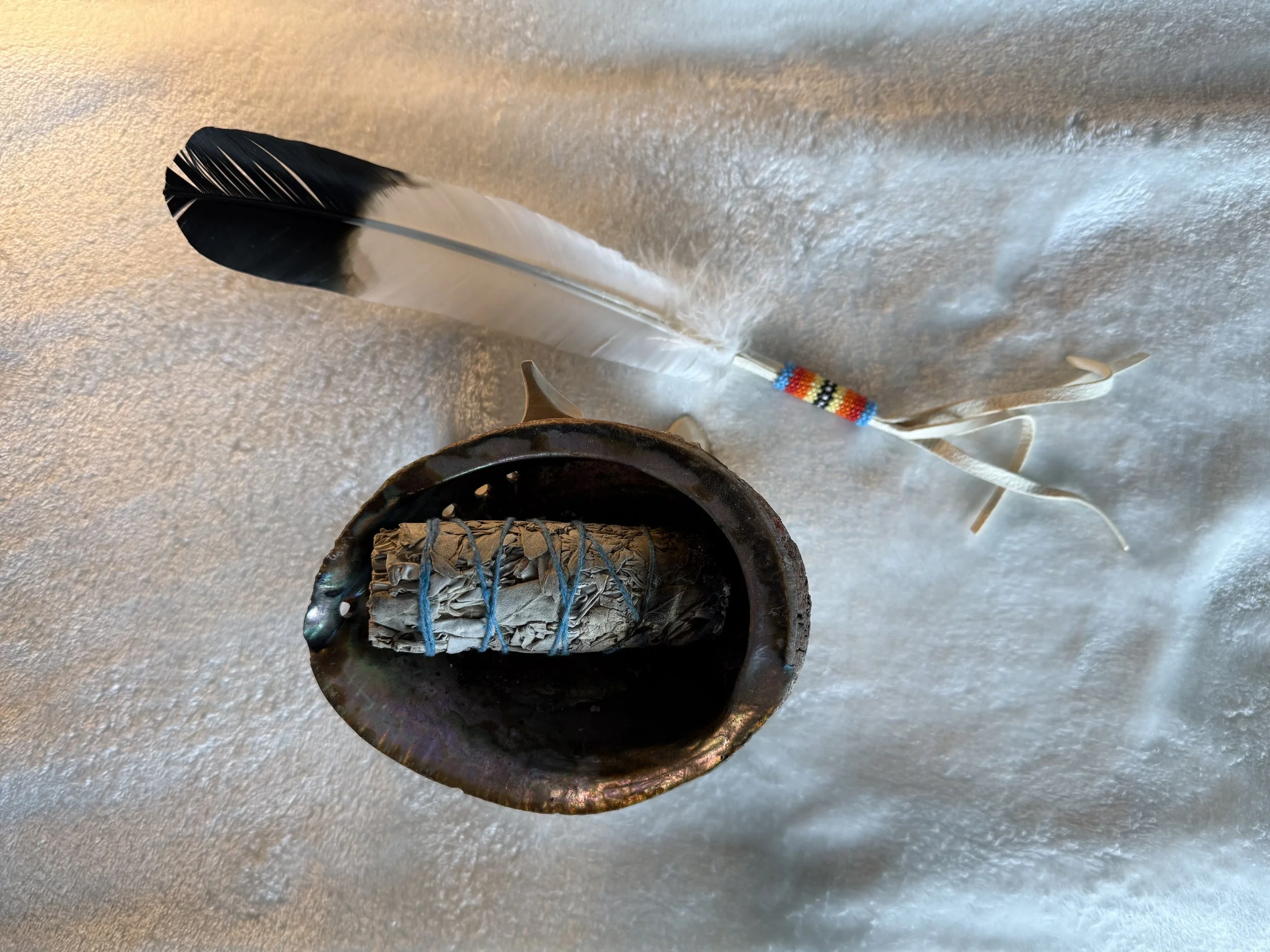 White sage and a turkey feather are traditional smudging tools to whisk away unwanted energies.