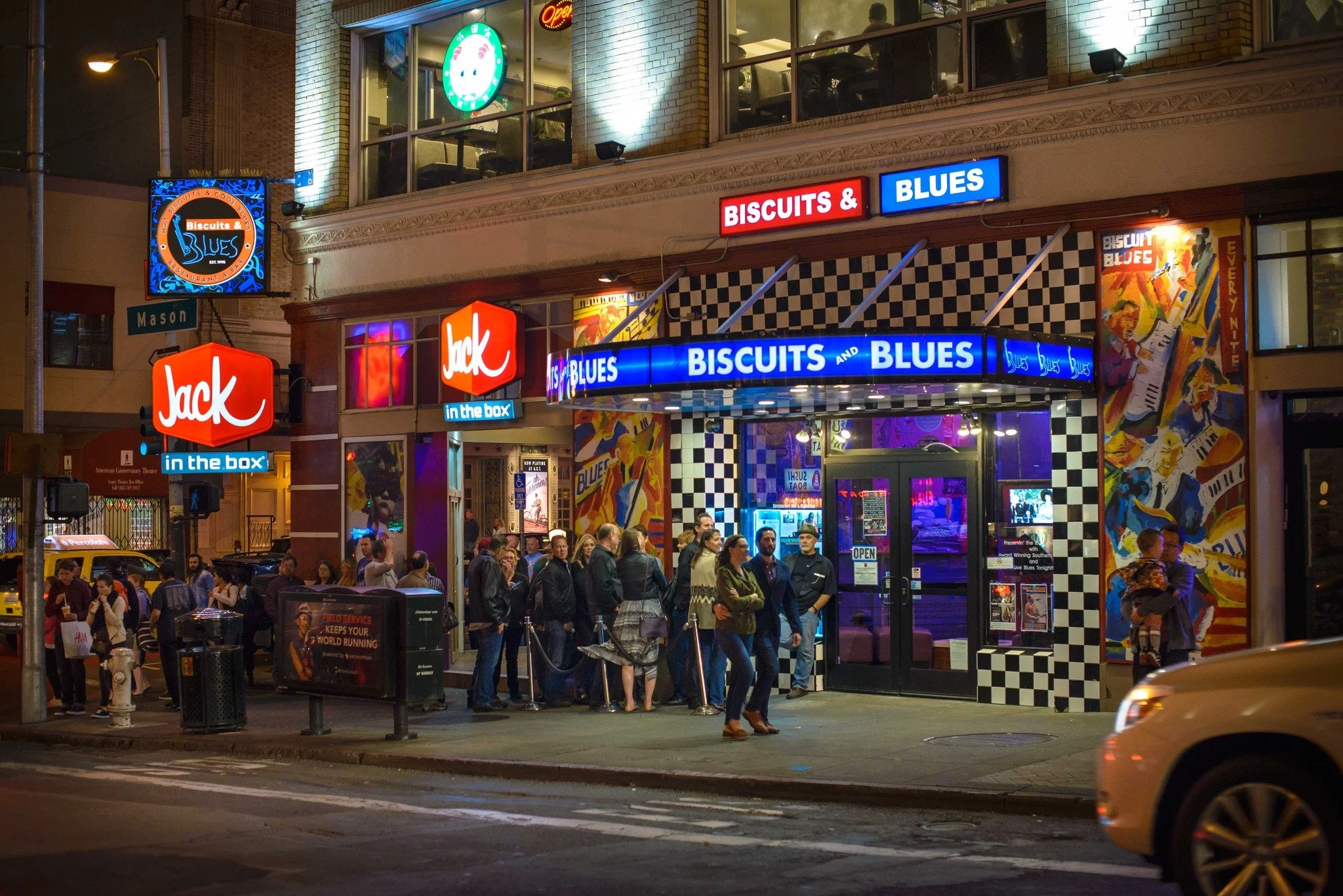 The Biscuits and Blues marquee lit up on Mason Street with a line waiting outside