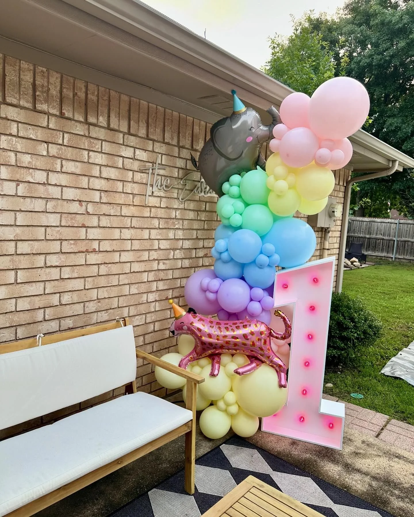 marquee number 1 with colored bulbs and balloon garland with foils