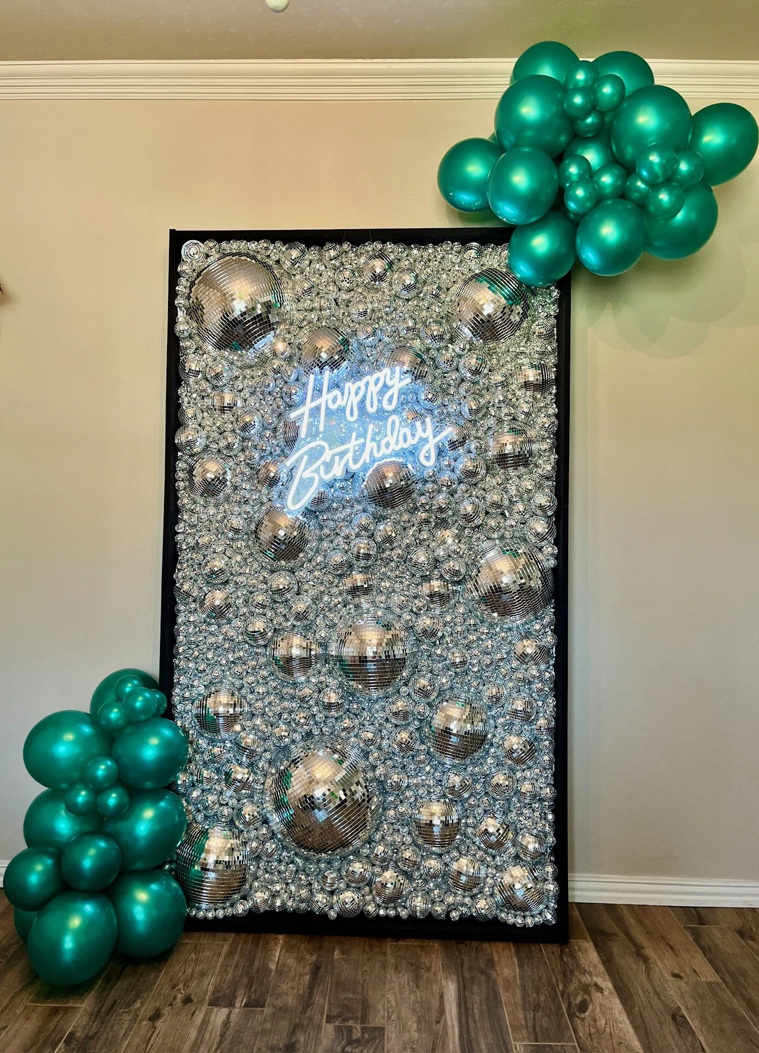 disco wall with balloon clusters and "happy birthday" neon sign
