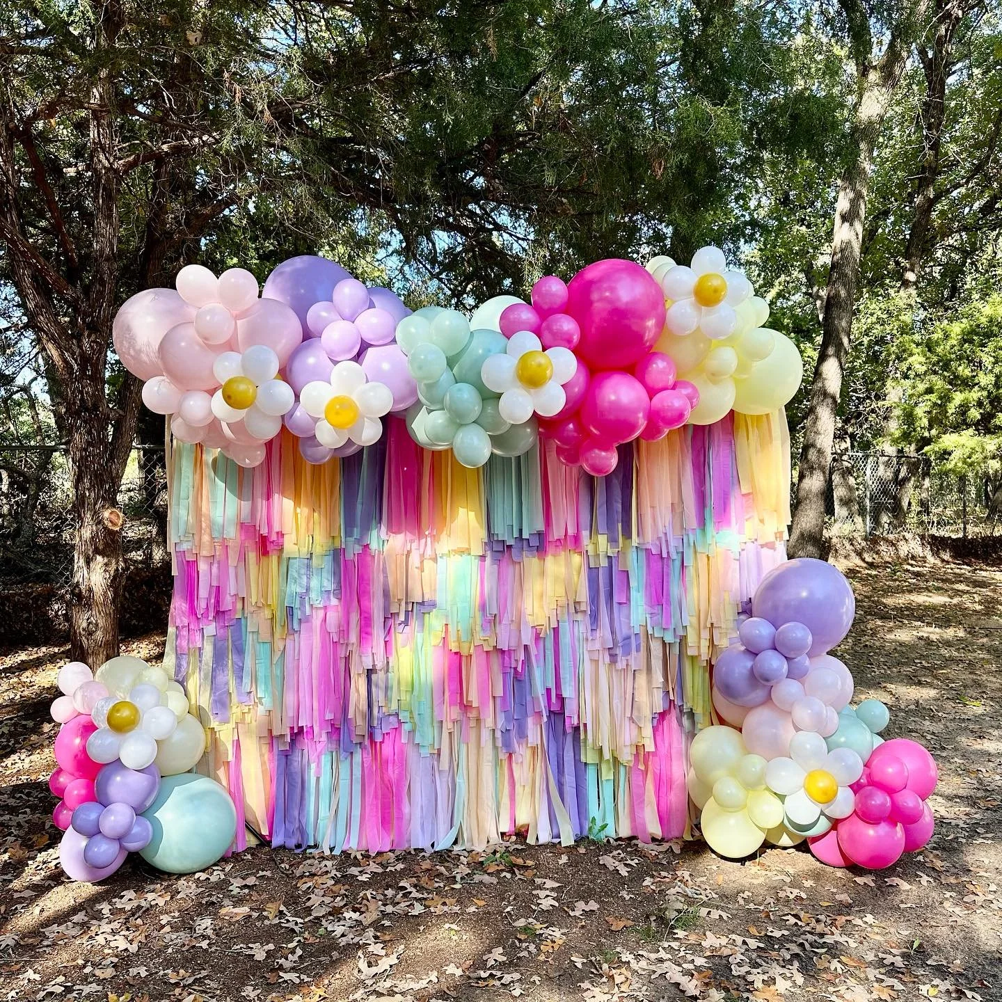 custom fringe backdrop with balloon garland and clusters