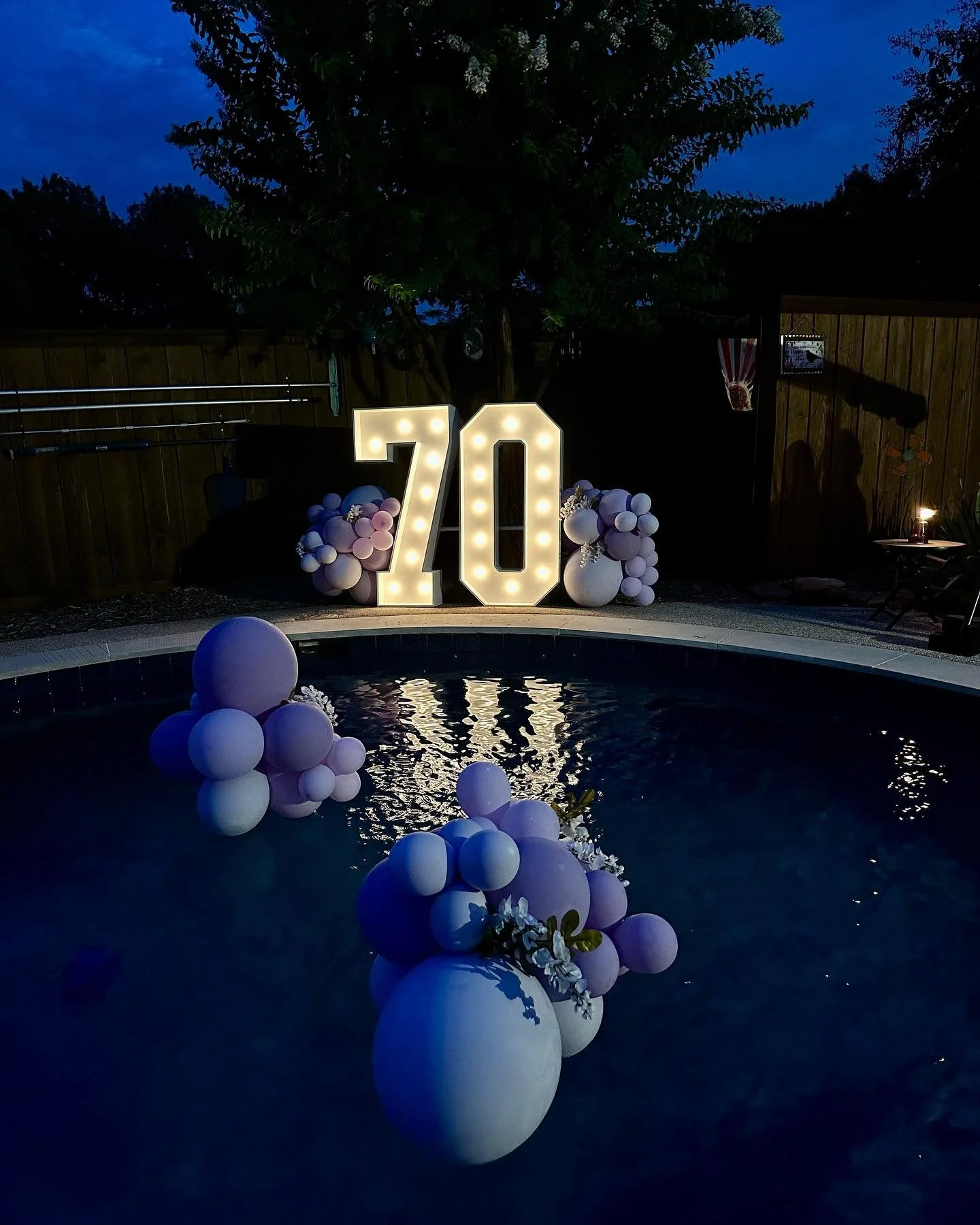 marquee numbers with balloon and balloon clusters in pool