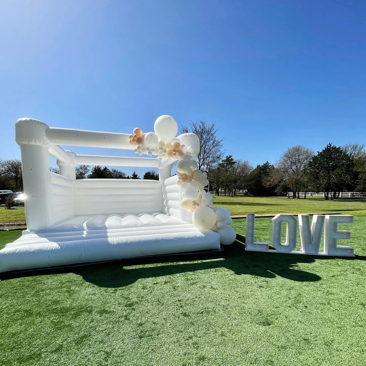 16x16 white bounce house with 10-12 ft balloon garland and marquee letters
