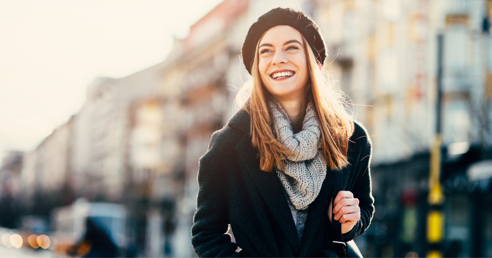 Woman smiling while traveling, appearing joyful and confident as she adapts to life after a recent medical diagnosis.