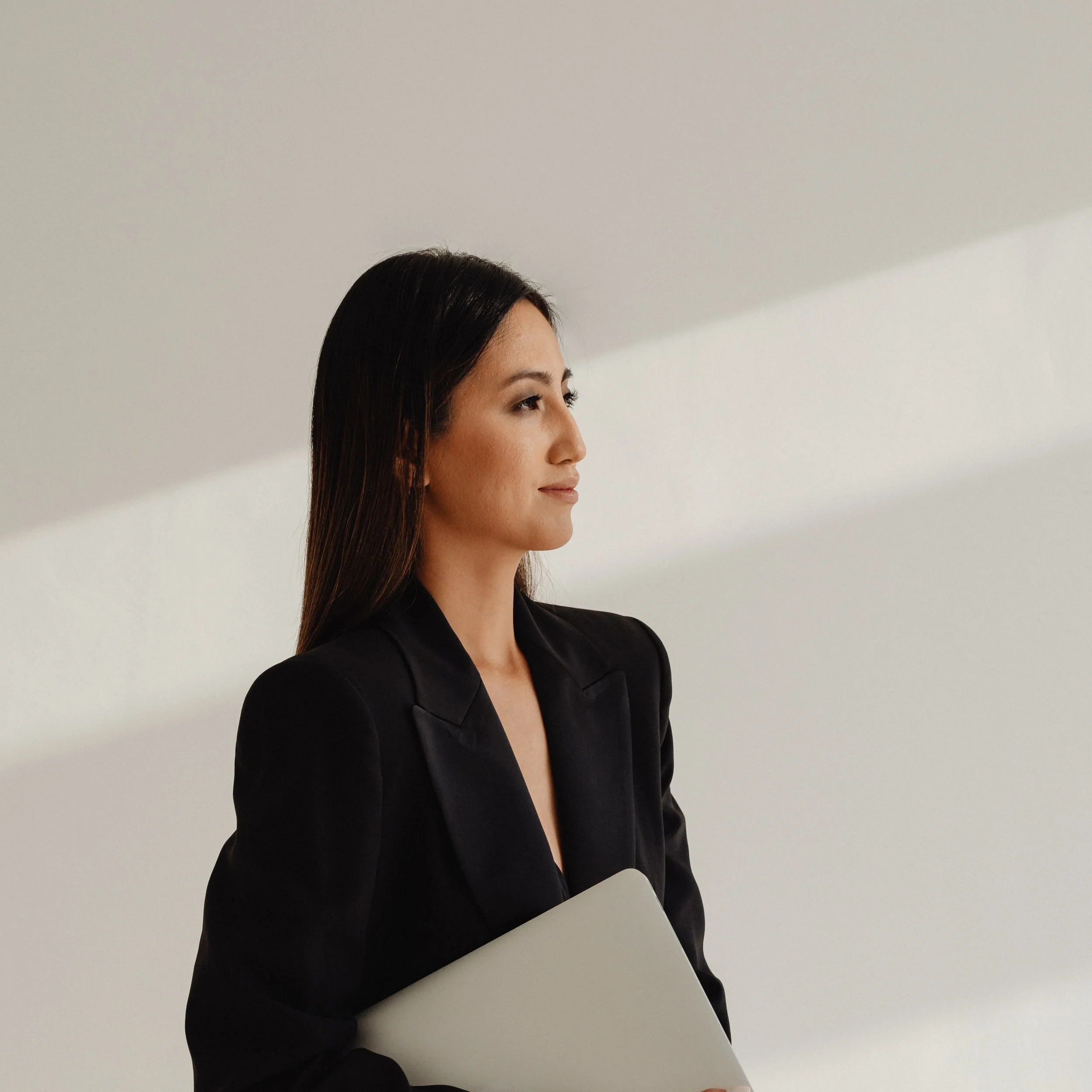 kaboompics_dark-classy-aesthetic-fashion-beautiful-asian-female-entrepreneur-in-black-suit-technology-and-devices-iphone-laptop-airpods-30068.jpg