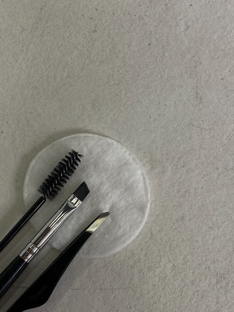 A makeup brush set positioned on a cotton round.
