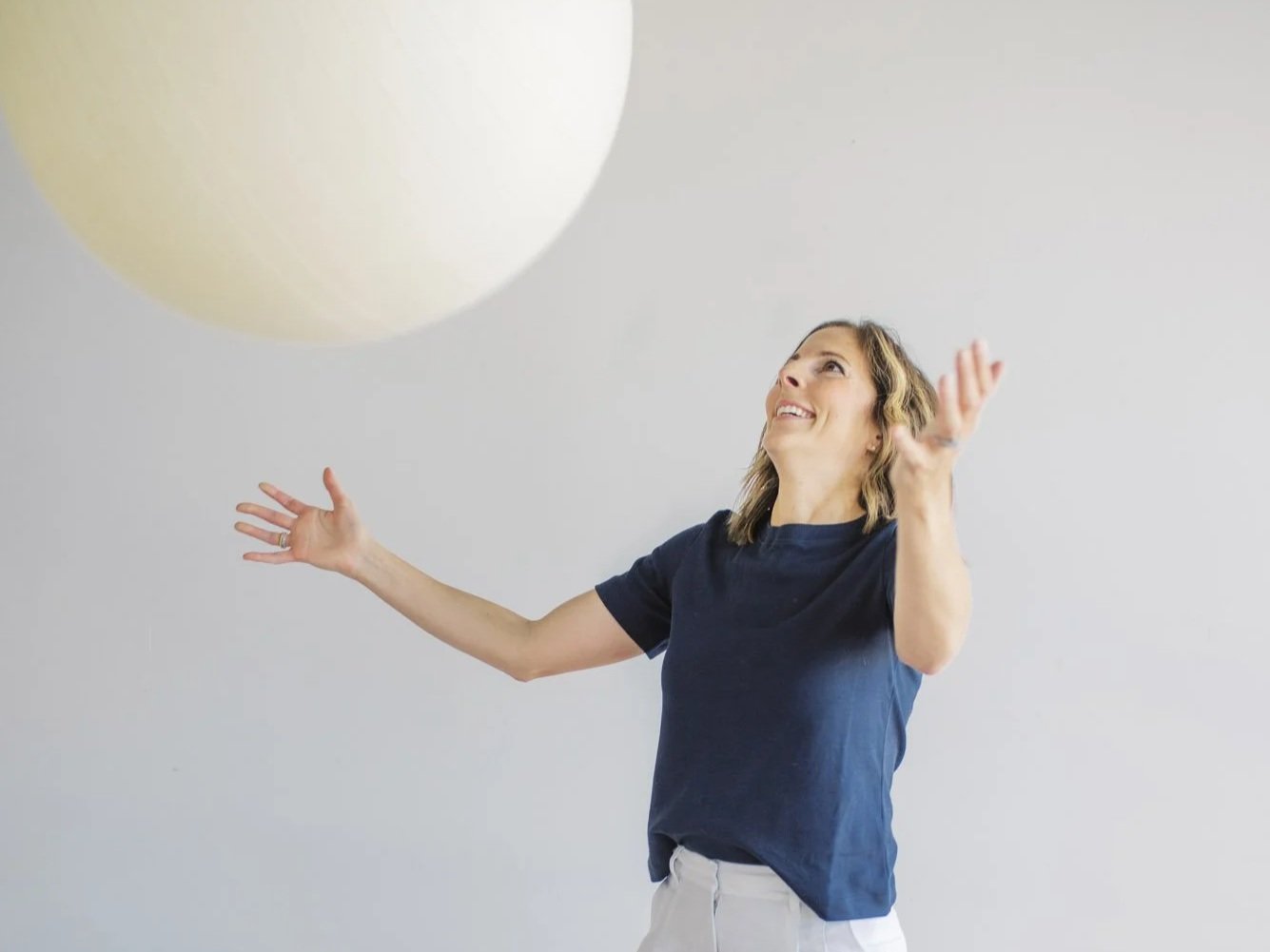Infant & Pediatric physical therapist using a large therapy ball for infant sensory and vestibular development during a PT session