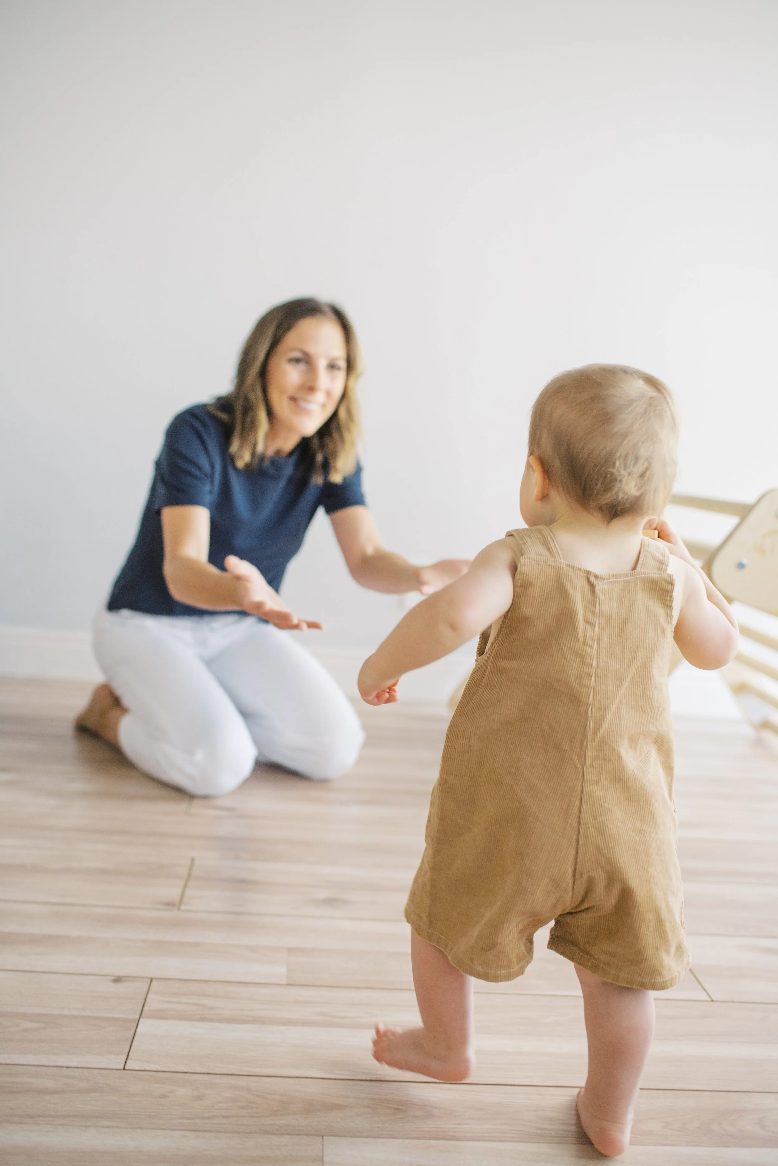 Infant taking independent steps toward their pediatric PT during a motor milestone session at Movevery Denver