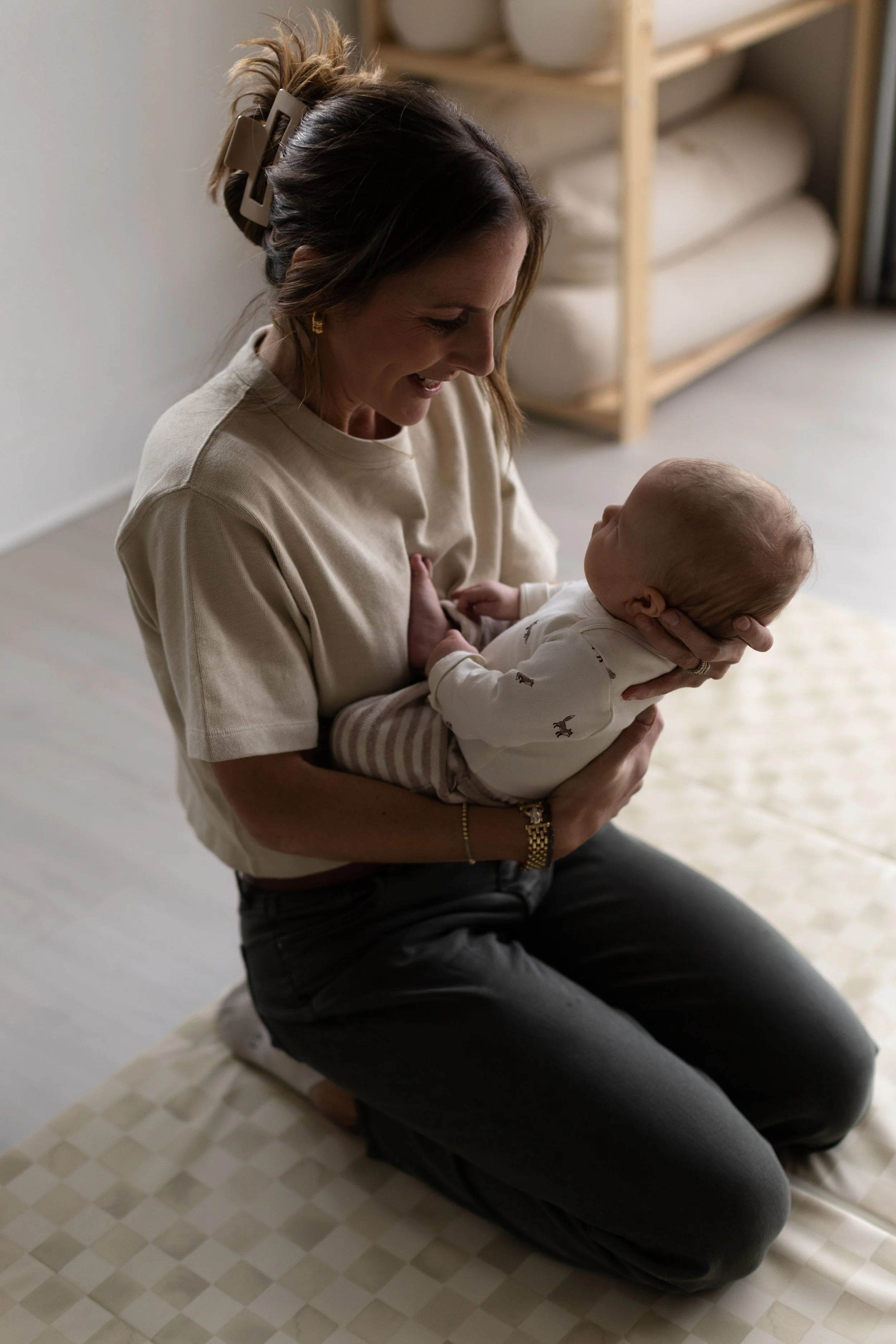 Pediatric physical therapist holding infant and supporting midline orientation during a torticollis evaluation at Movevery
