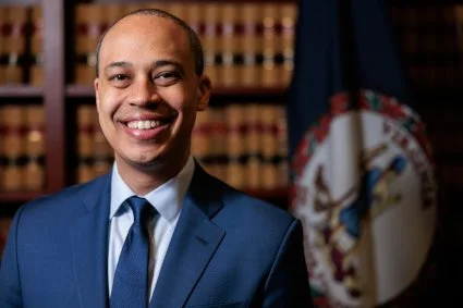 official portrait of man smiling in blue suit