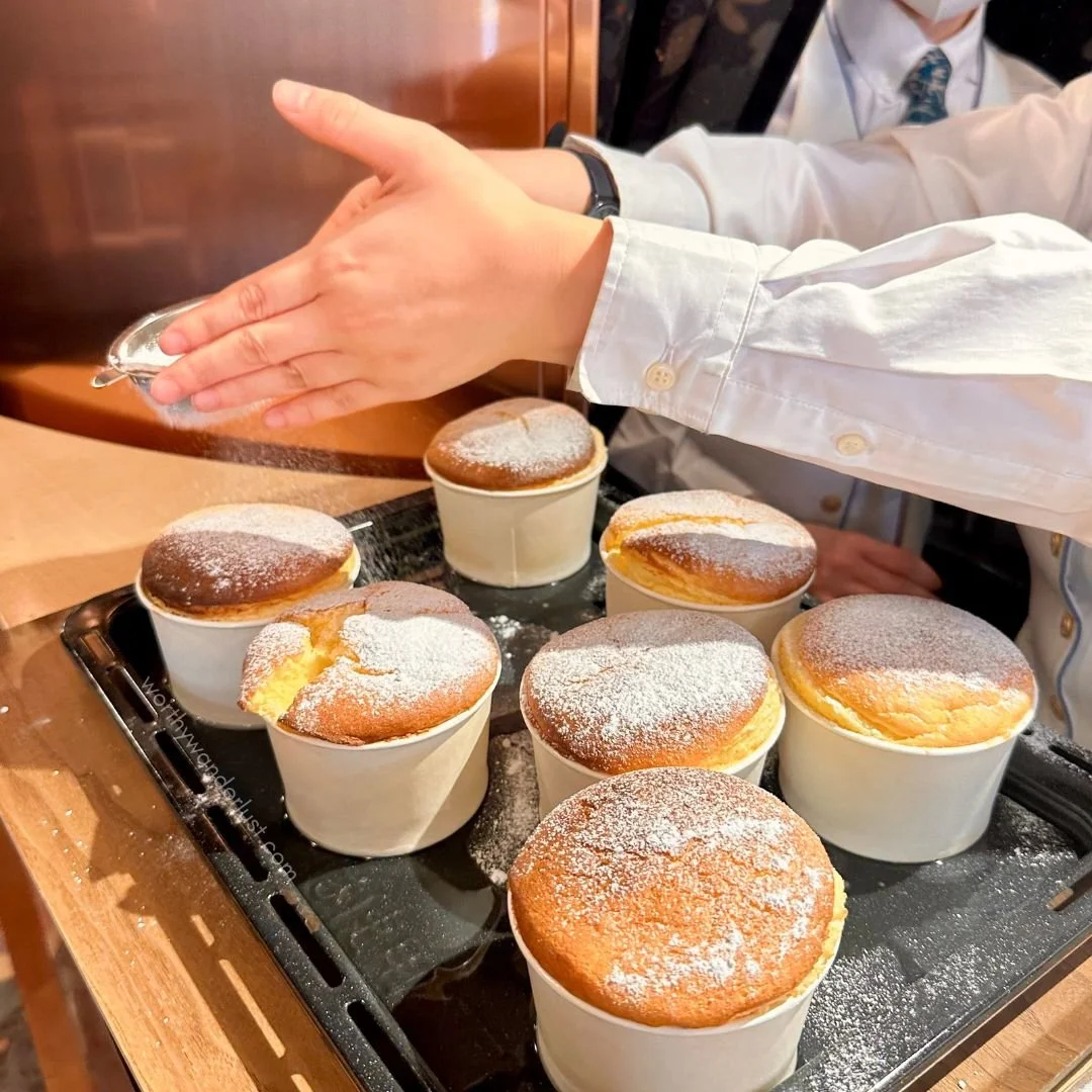 Hand dusting icing sugar on souffles