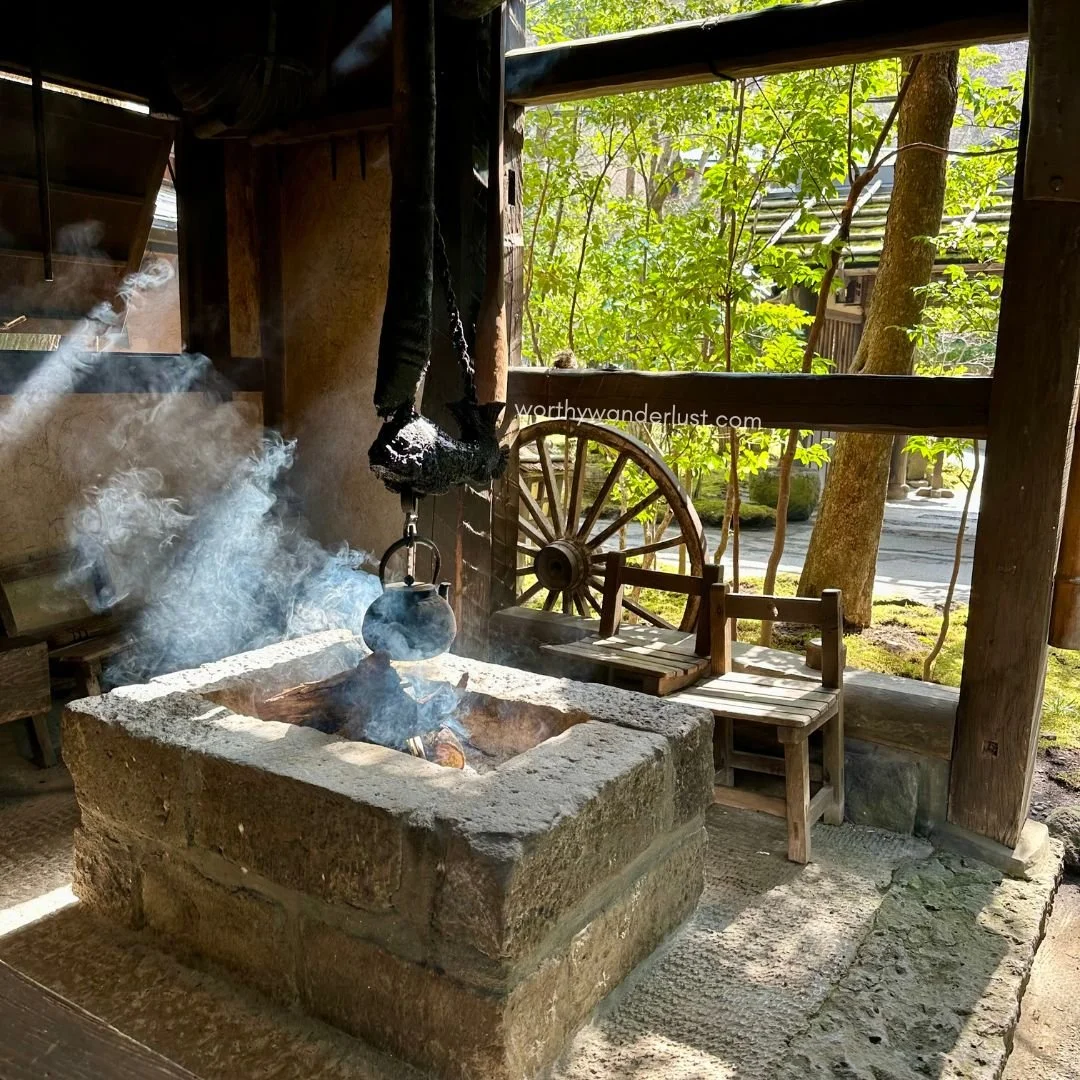 A kettle boiling over an open fire, with steam rising, at Oyado Noshiyu in Kurokawa Onsen