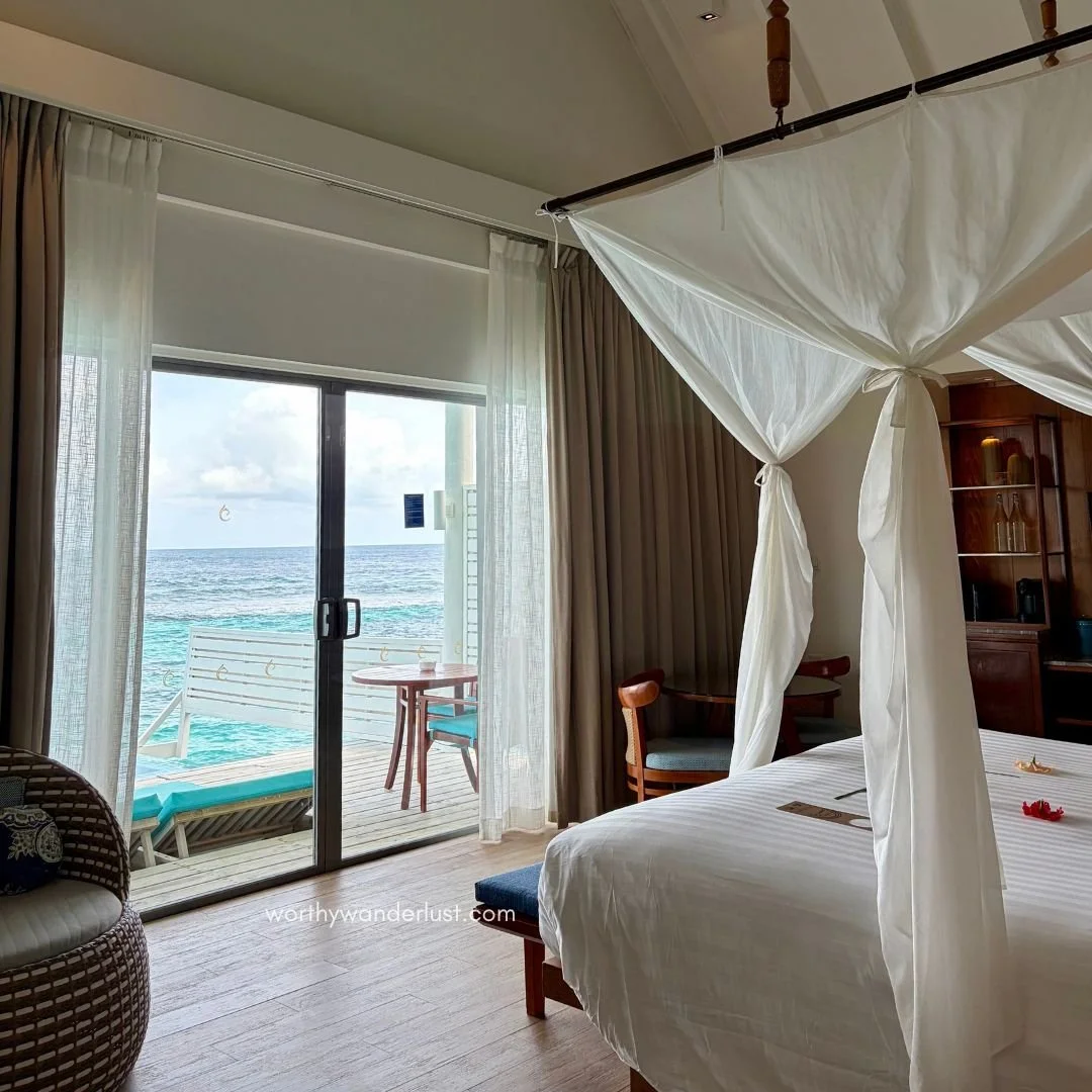 Villa bedroom looking out onto deck and deck chairs.