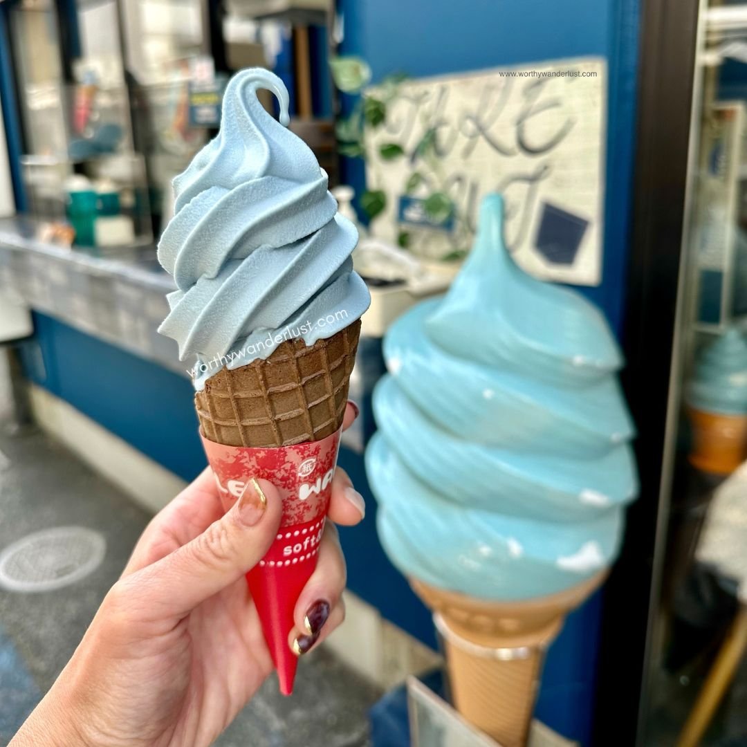 Hand holding up blue soft serve ice cream in Kurashiki Denim Street