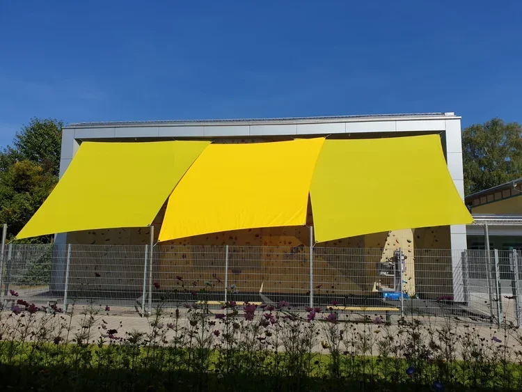 Slnečná plachta pri modernom rodinnom dome.