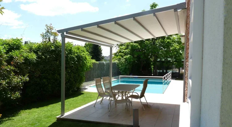 Látková pergola s poťahom z pevného PVC na terase moderného rodinného domu.