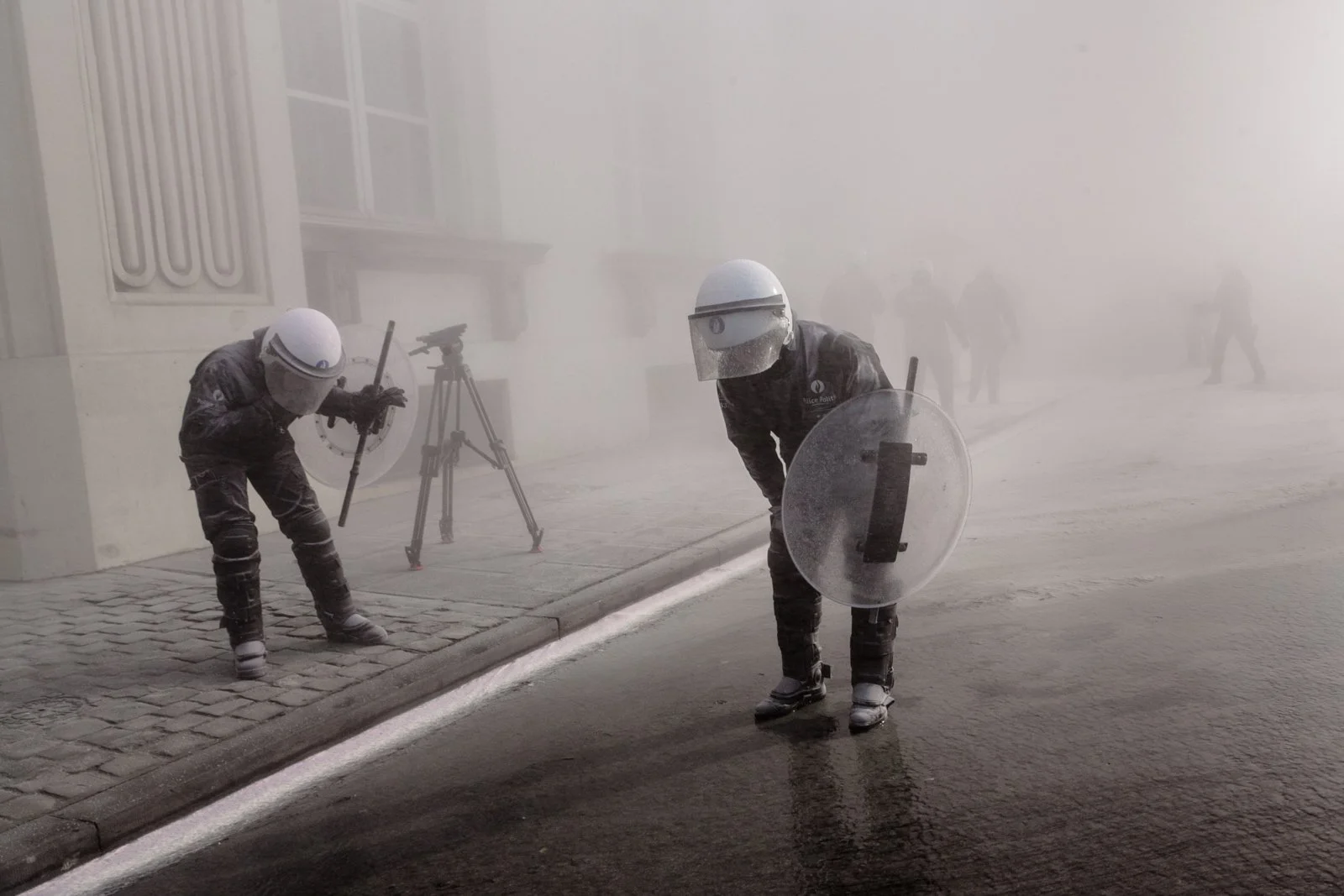 Policemen in a cloud of powder at a protest of firemen