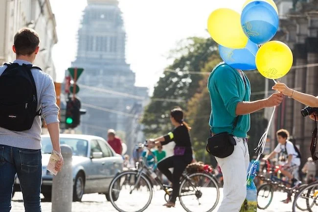 Man takes balloons in the center of Brussels photographed by a professional photographer