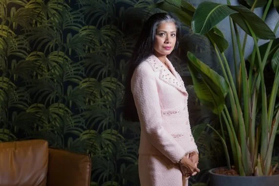 portrait of a beautiful woman in pink standing in front of plants