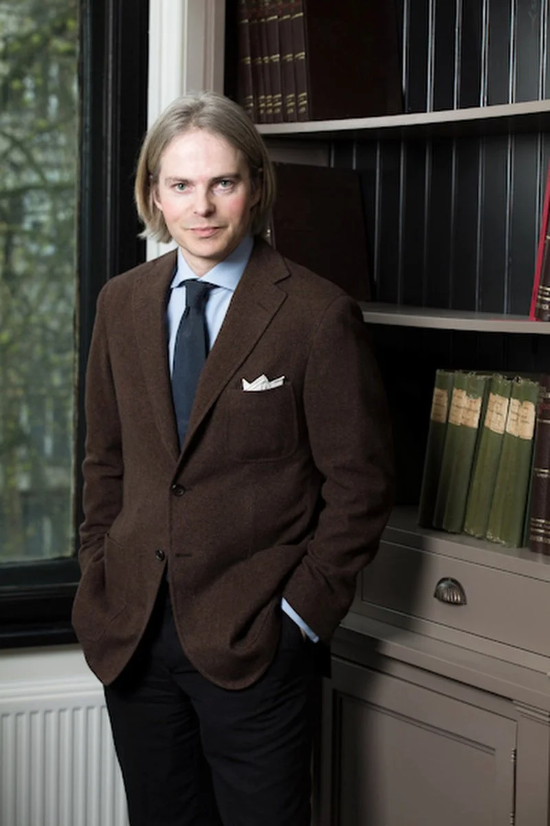 Portrait on location of a man in front of law books