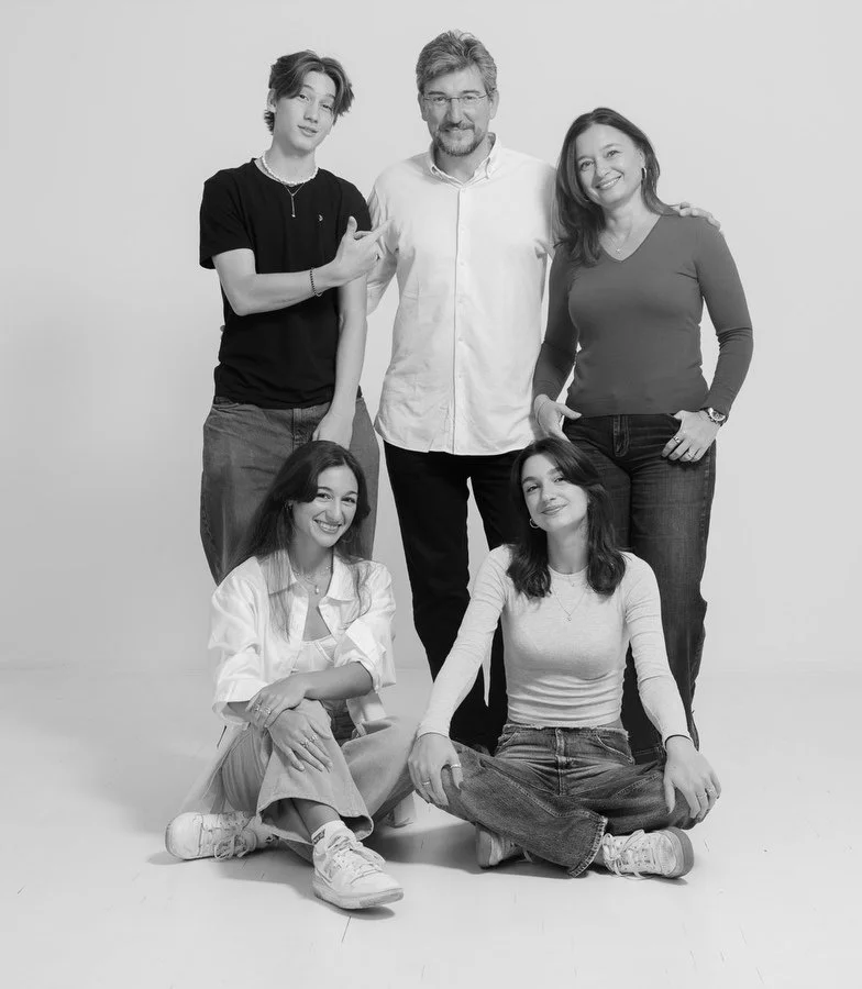 A black and White family portrait in the studio of parents and three kids together