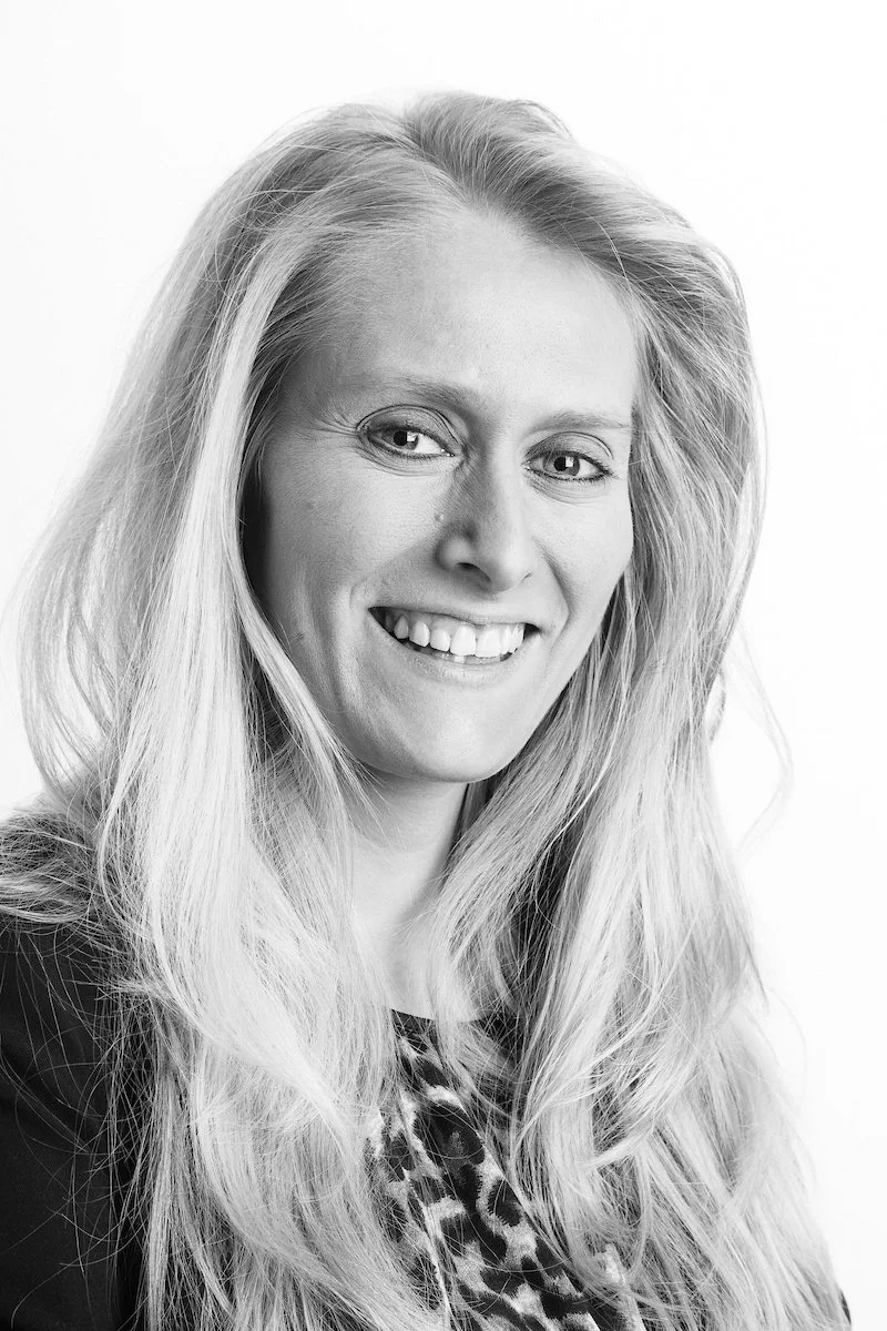 Photo en noir et blanc d'une femme souriante aux longs cheveux blonds.