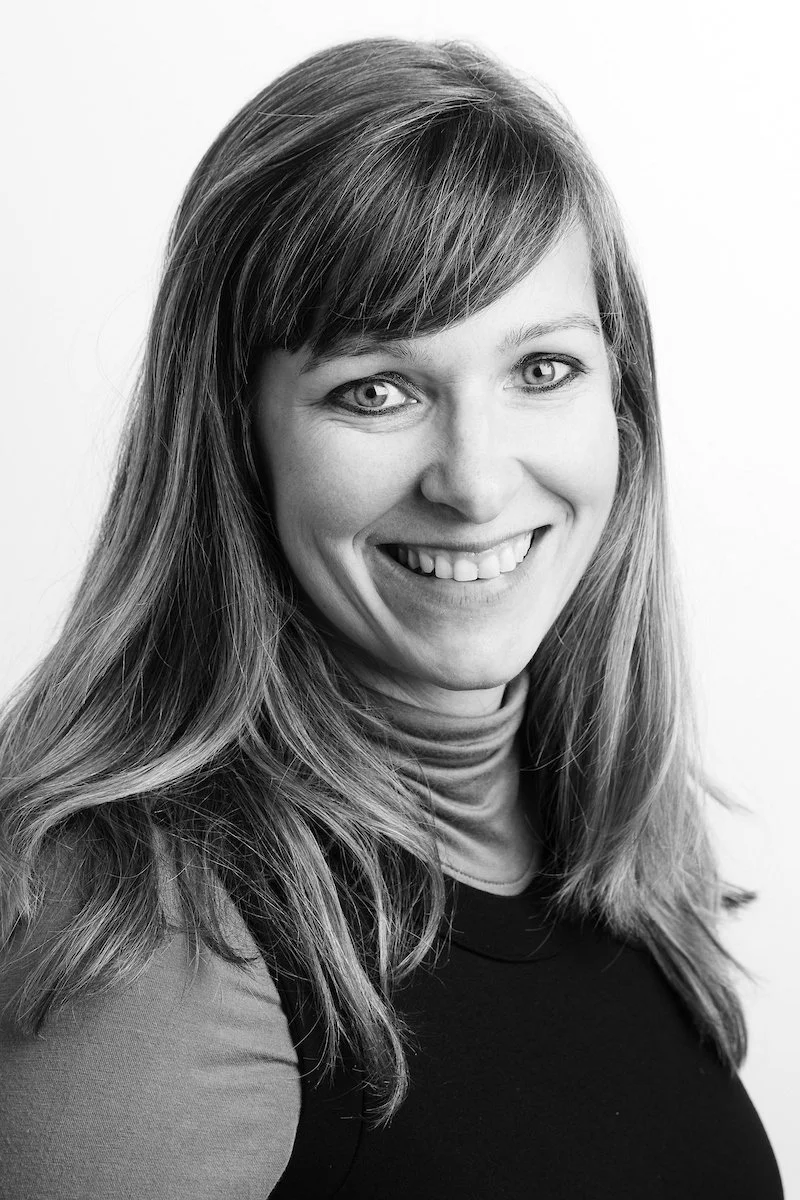 Femme souriante aux cheveux longs dans un portrait en noir et blanc.