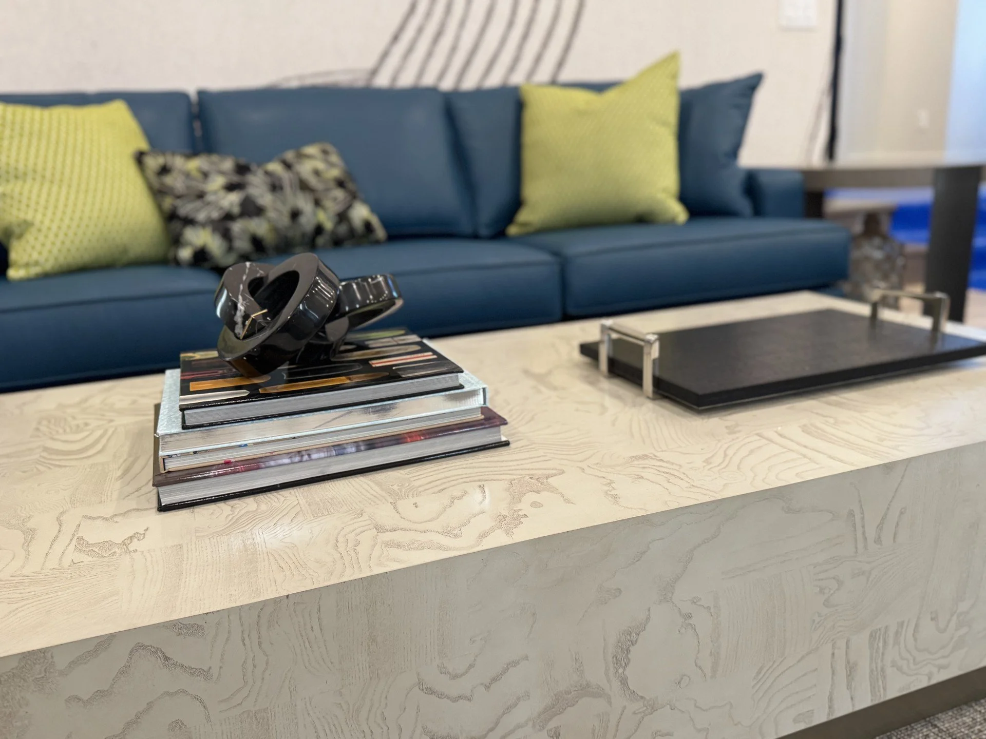 Mix of colorful modern throw pillows on teal sofa in bold beach house living room