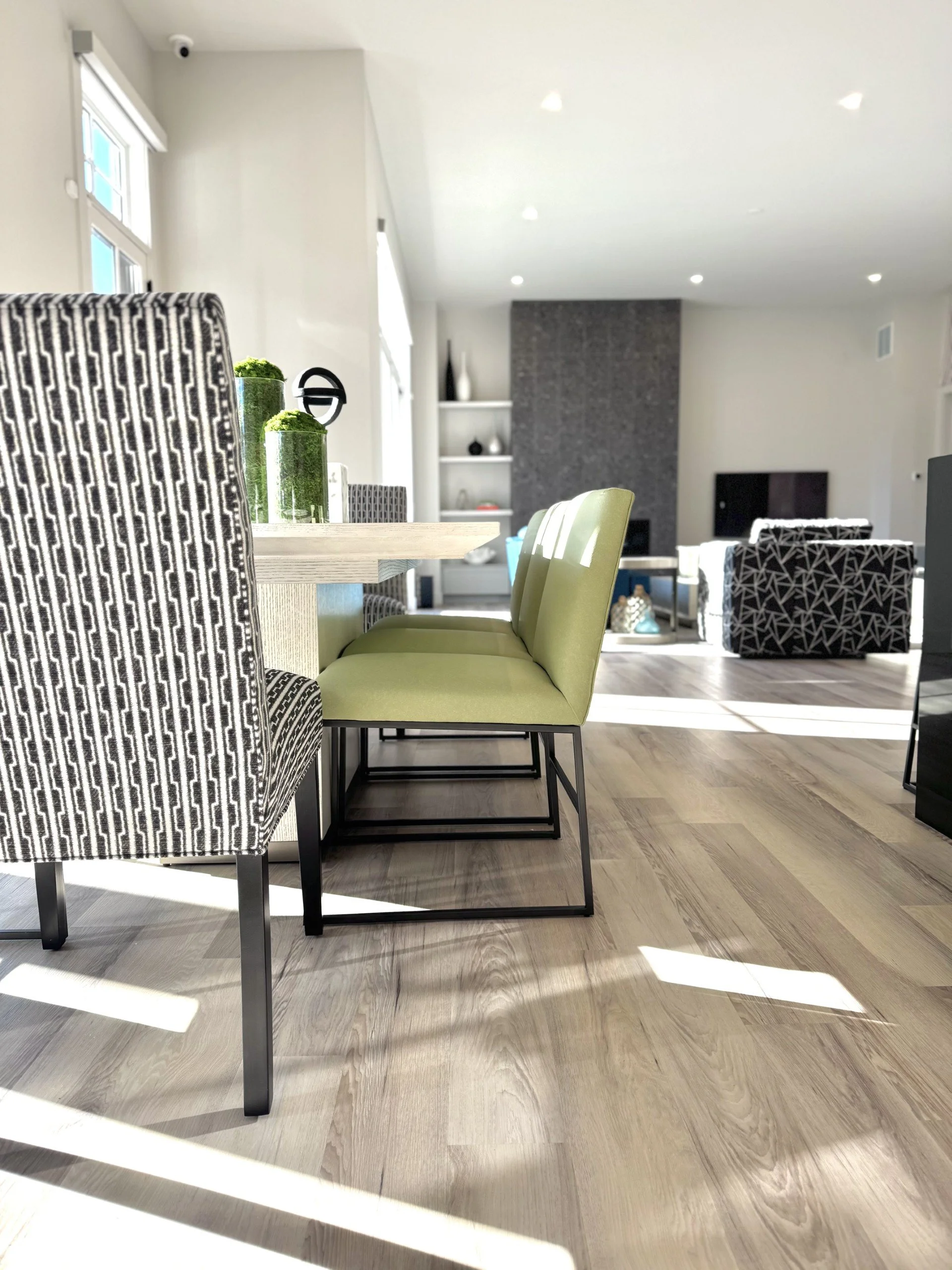 Modern dining room with white dining table and citron green metal dining chairs in a colorful beach house