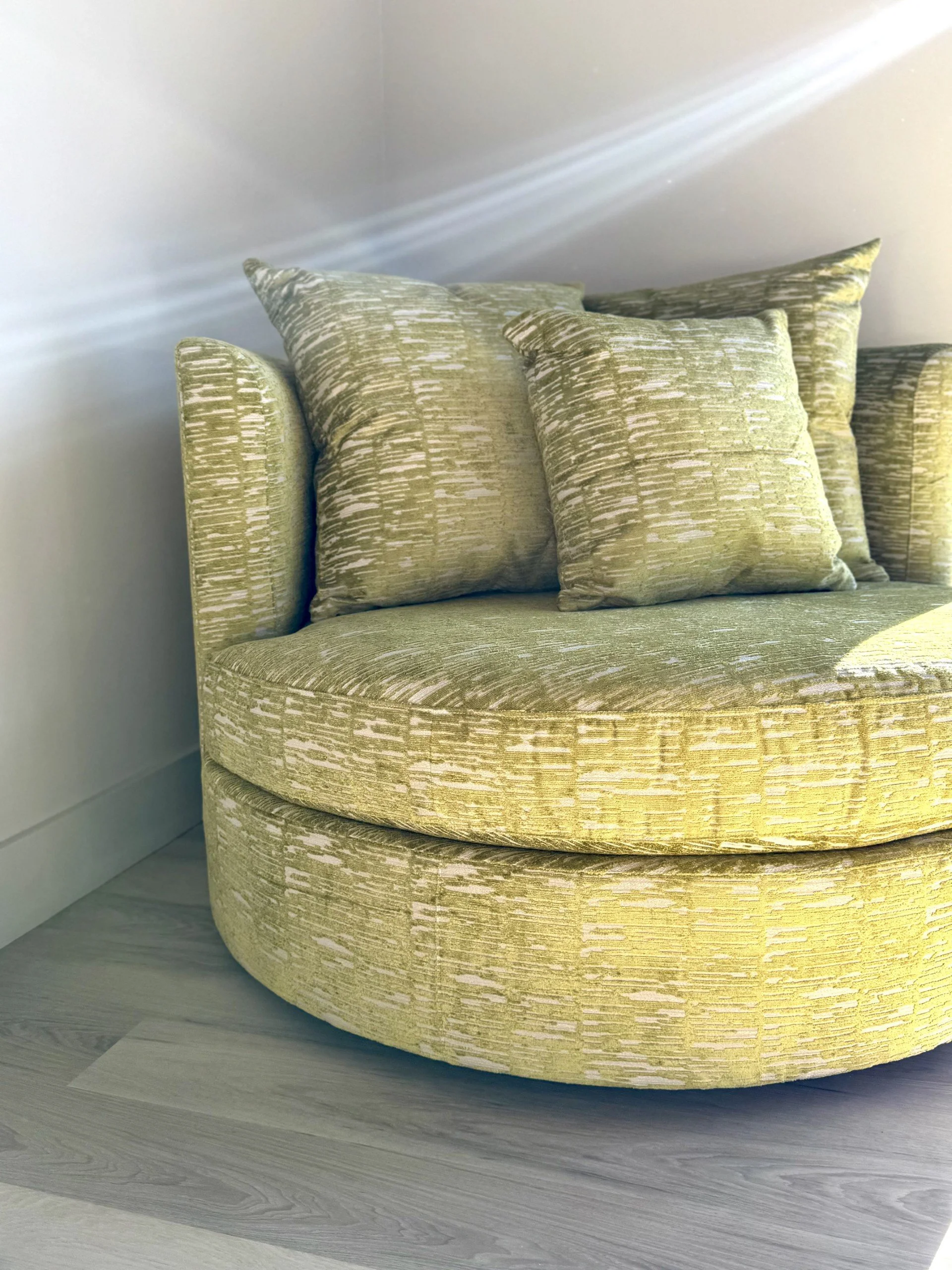 Lime green velvet swivel chair in a modern black bedroom reading corner