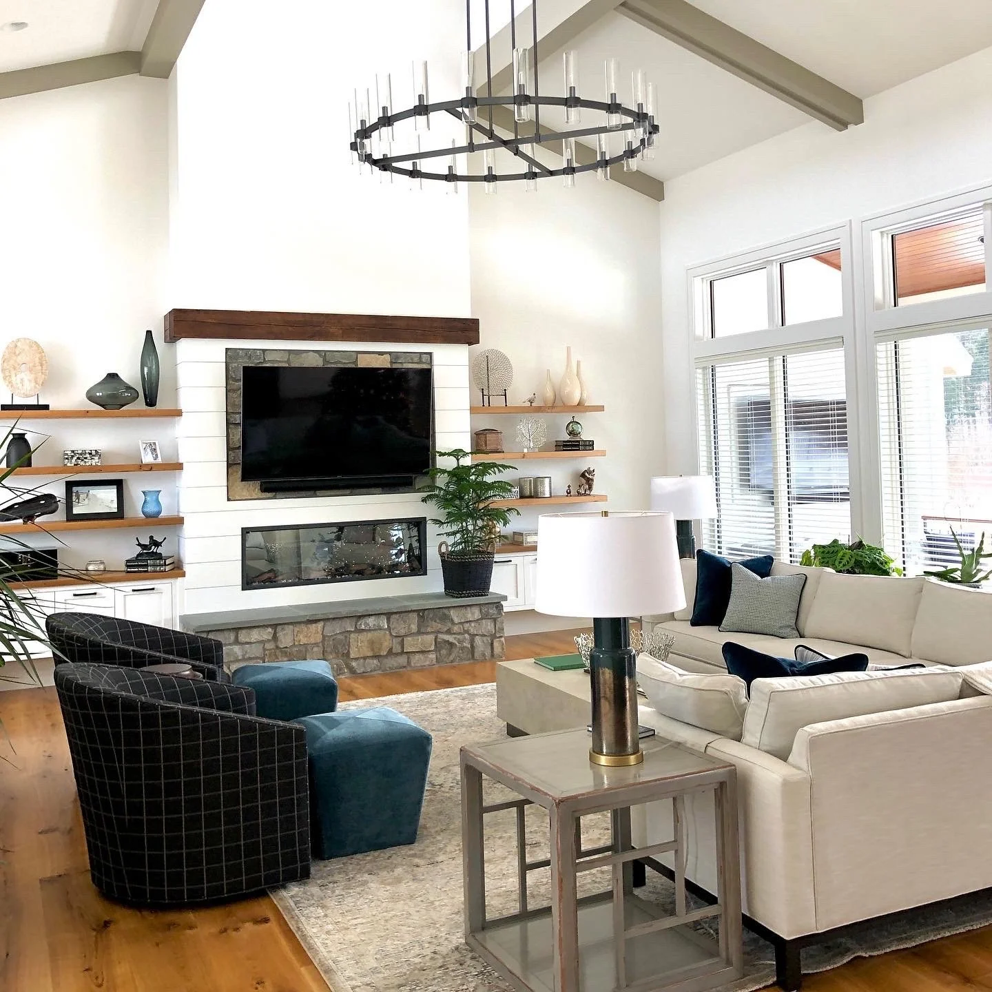 interior design ethan allen living room design with stone and ship lap fireplace and floating shelves with sectional end table and lamp and black plaid chairs and teal ottomans