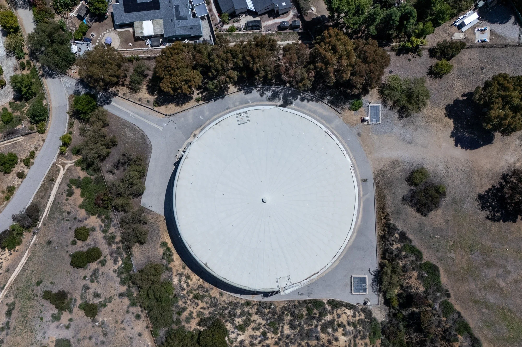 Aerial drone photo of a large circular facility roof and hillside site in Thousand Oaks, captured by Dragon Media.
