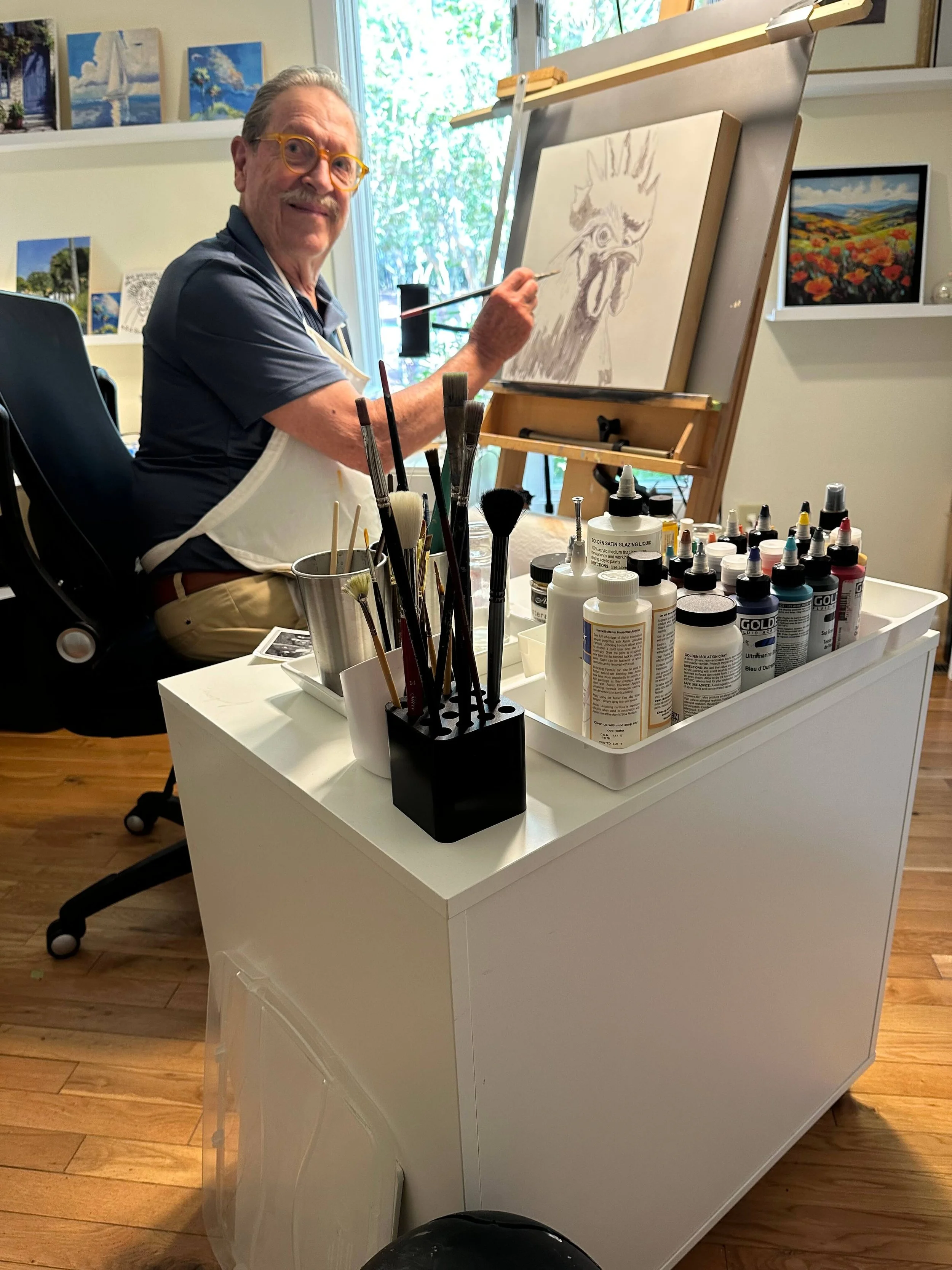 Charlie Roberts painting at his easel in his studio
