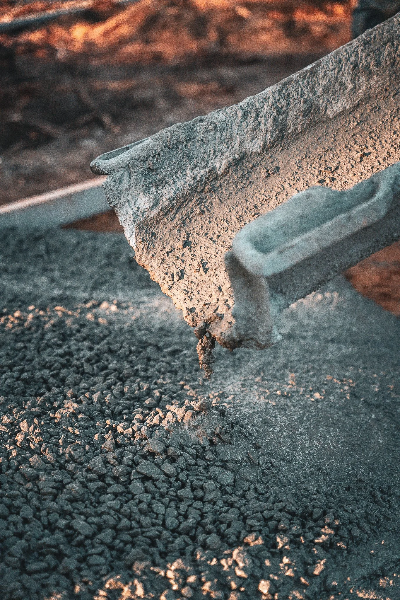Close-up of a concrete trowel lifting wet concrete or asphalt during paving.